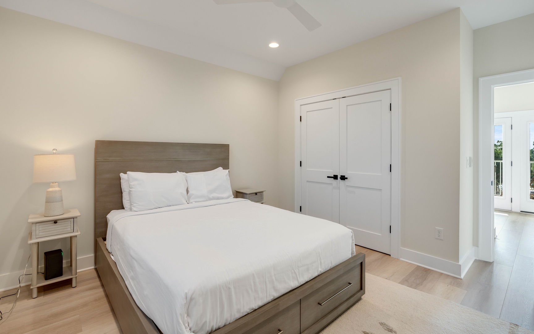 Unwind in your serene bedroom featuring crisp white linens, warm wood tones, and thoughtful storage solutions for the perfect night's rest.