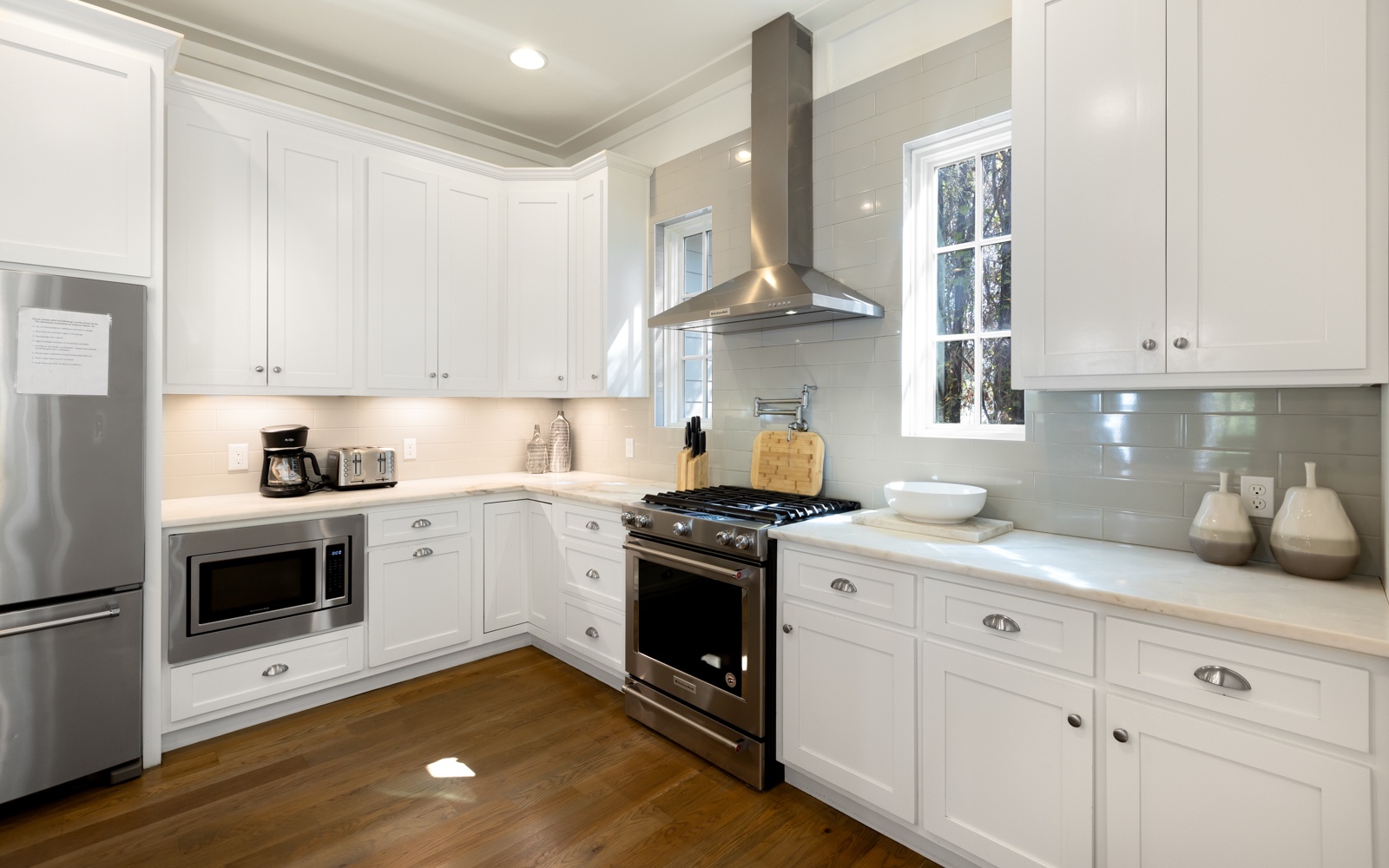 Your spacious chef's kitchen gleams with pristine white cabinets, modern stainless appliances, and everything you need to create memorable meals during your stay.