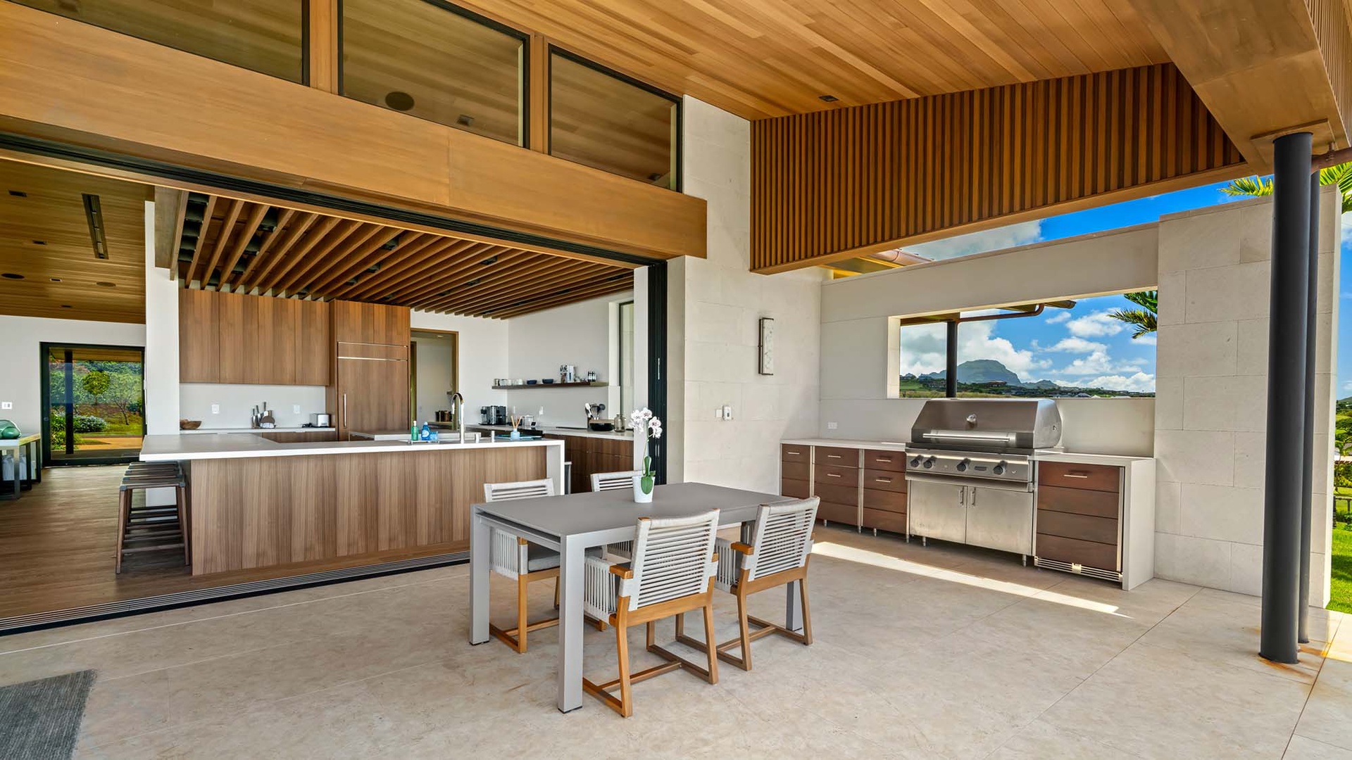 Your private indoor-outdoor retreat blends sleek modern design with island tranquility. Cook with views of tropical skies, dine under rich wooden ceilings, and enjoy seamless flow between kitchen and outdoor grill station.