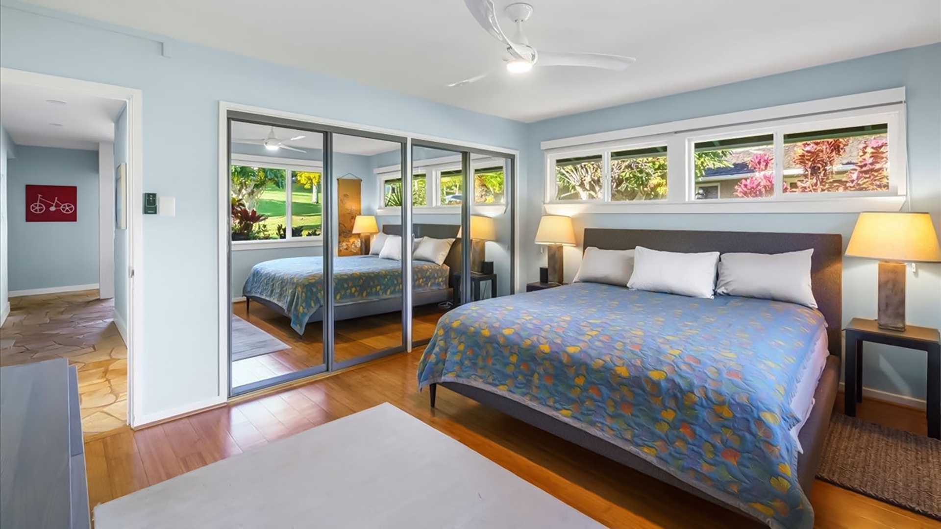 Drift off in your peaceful bedroom with warm bedside lighting, mirrored wardrobes, and garden views through bright windows.