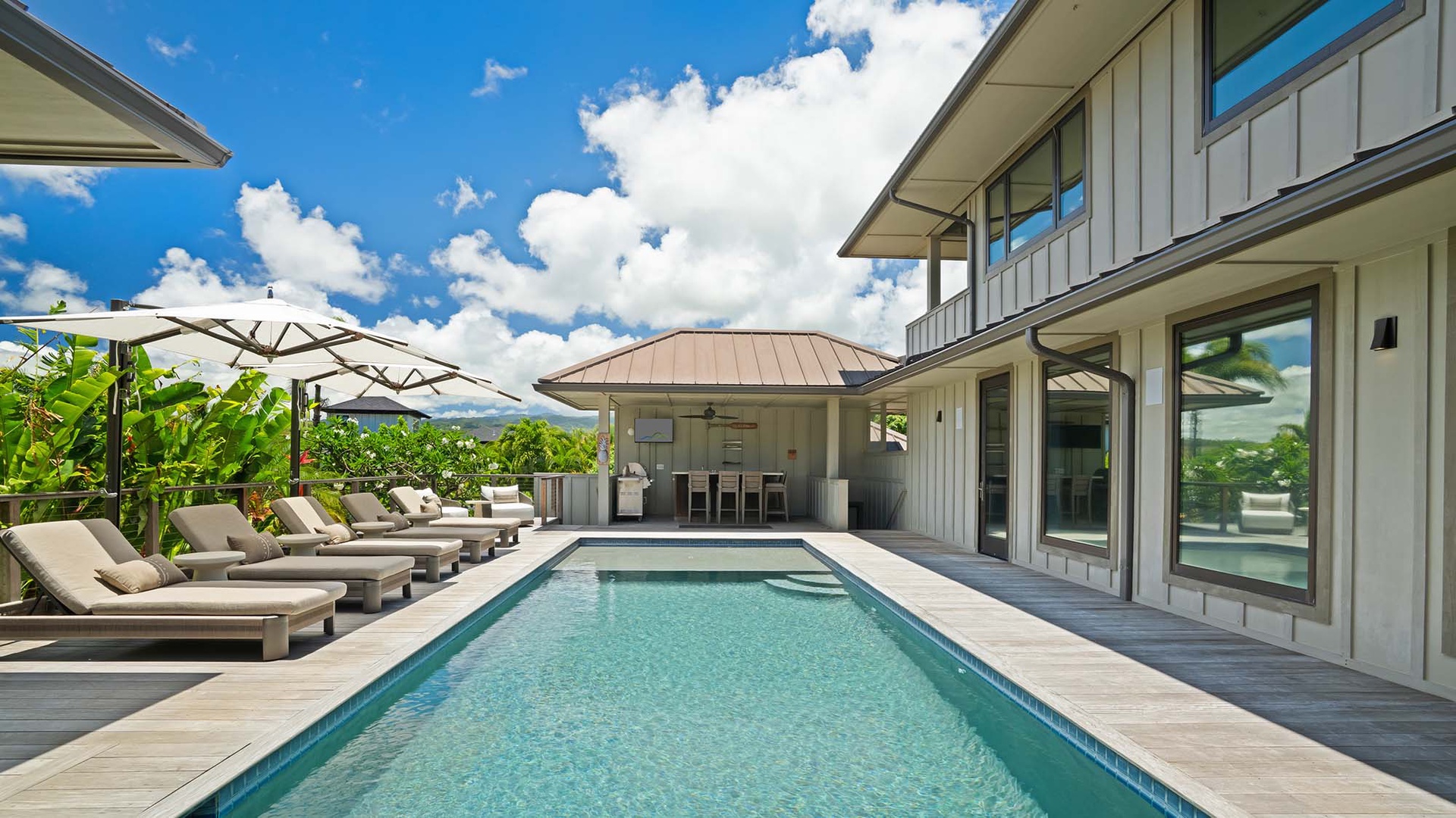 Picture yourself lounging poolside, soaking up the sun while tropical breezes and stunning mountain vistas surround you. Your private oasis awaits with sleek outdoor dining and endless relaxation.