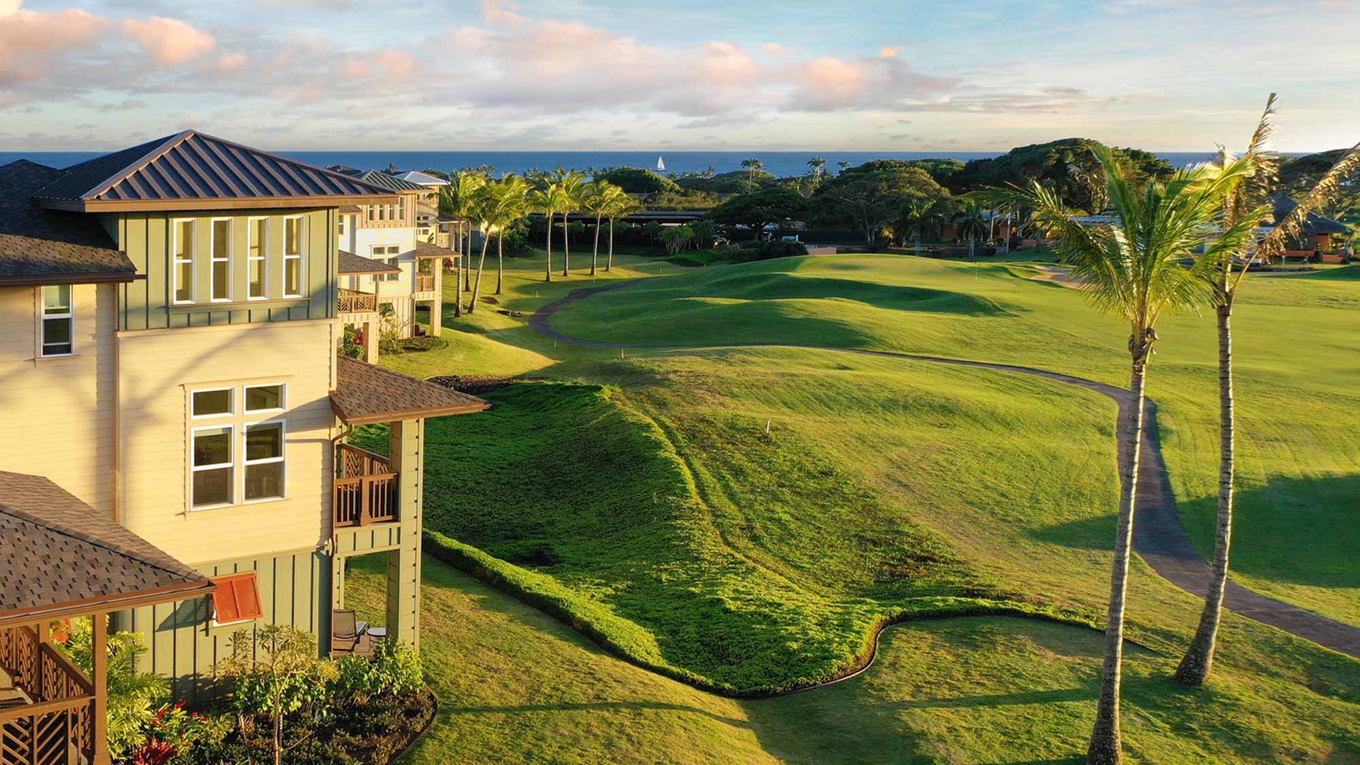 This property sits within a picturesque golf course community, framed by swaying palms and distant ocean views. Lush greens stretch across the landscape, creating a serene tropical retreat.