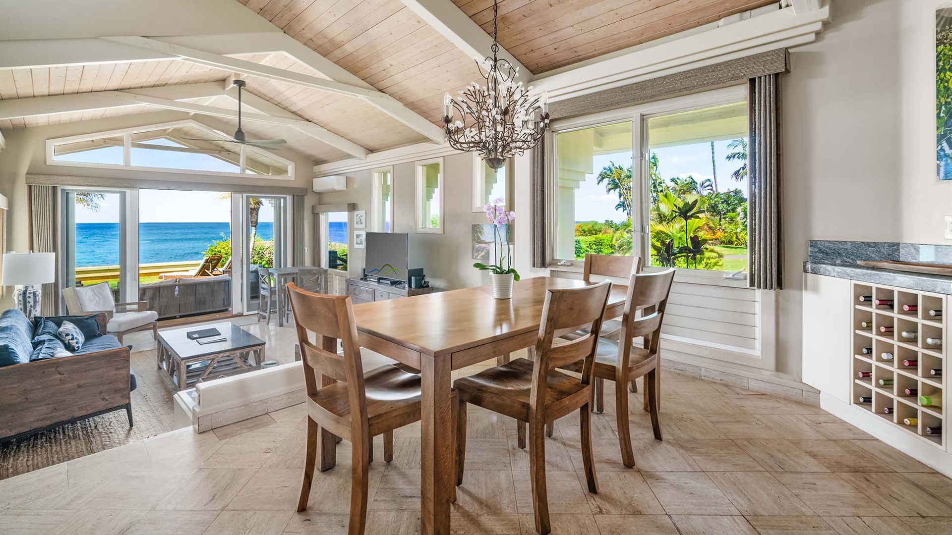 Relax in this sun-drenched open-plan living and dining area, where stunning ocean views greet you through every window. Feel the tropical breeze as you dine under the elegant chandelier.
