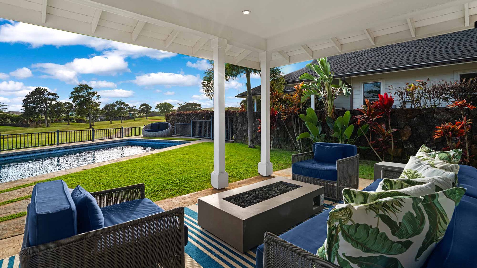 Relax in your covered lanai overlooking tropical gardens, a sparkling pool, and lush fairway views—the perfect outdoor retreat.