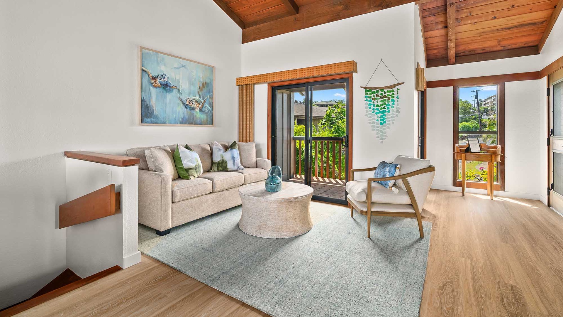 Unwind in your bright living space with soaring wood ceilings, cozy seating, and French doors opening to your private balcony framed by lush greenery and tropical views.