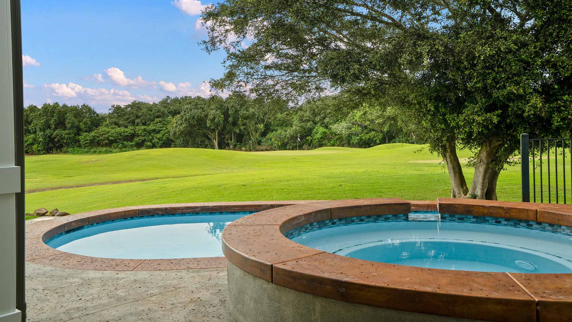 Unwind in your private hot tub overlooking pristine golf course greens, where rolling fairways meet endless blue skies for the perfect peaceful retreat.