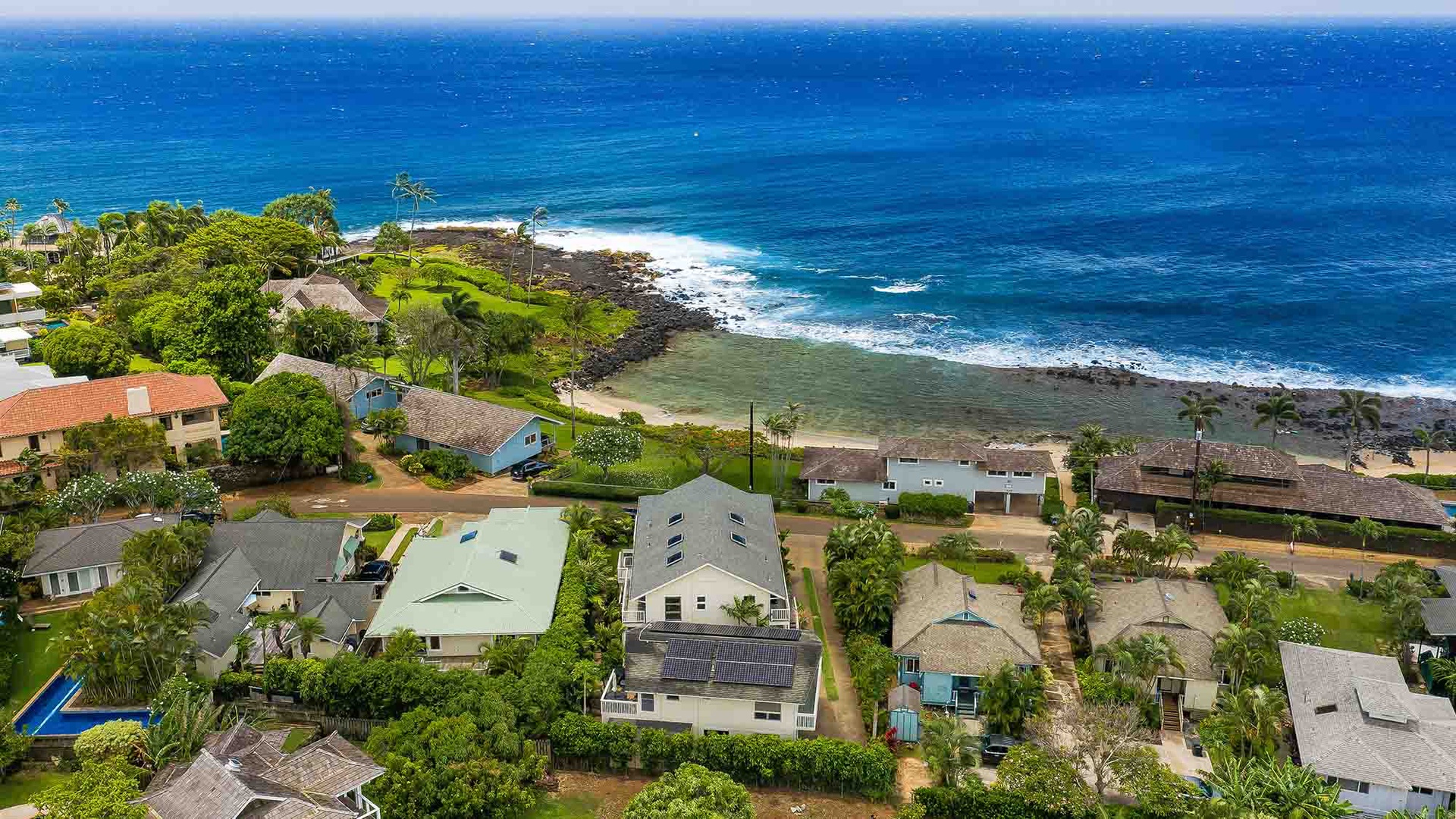 Coastal neighborhood featuring vacation rental properties nestled along pristine shoreline with spectacular ocean views and lush tropical landscaping throughout the area.