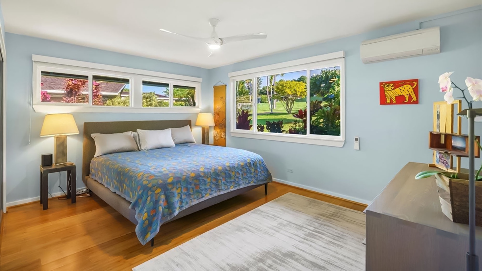 Your peaceful bedroom sanctuary features calming blue walls and garden views to help you unwind after exploring.