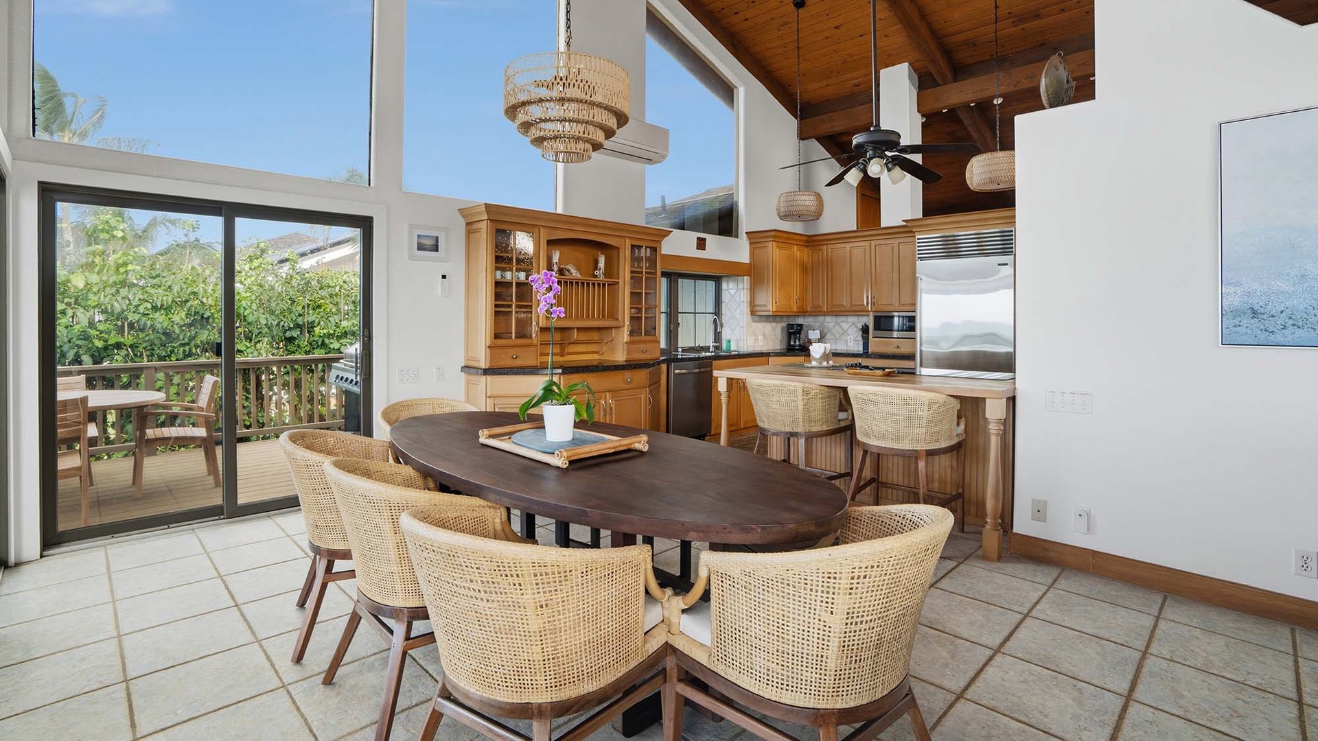 Gather around this stunning oval dining table where warm wood tones and woven textures create your perfect setting for memorable meals with garden views.