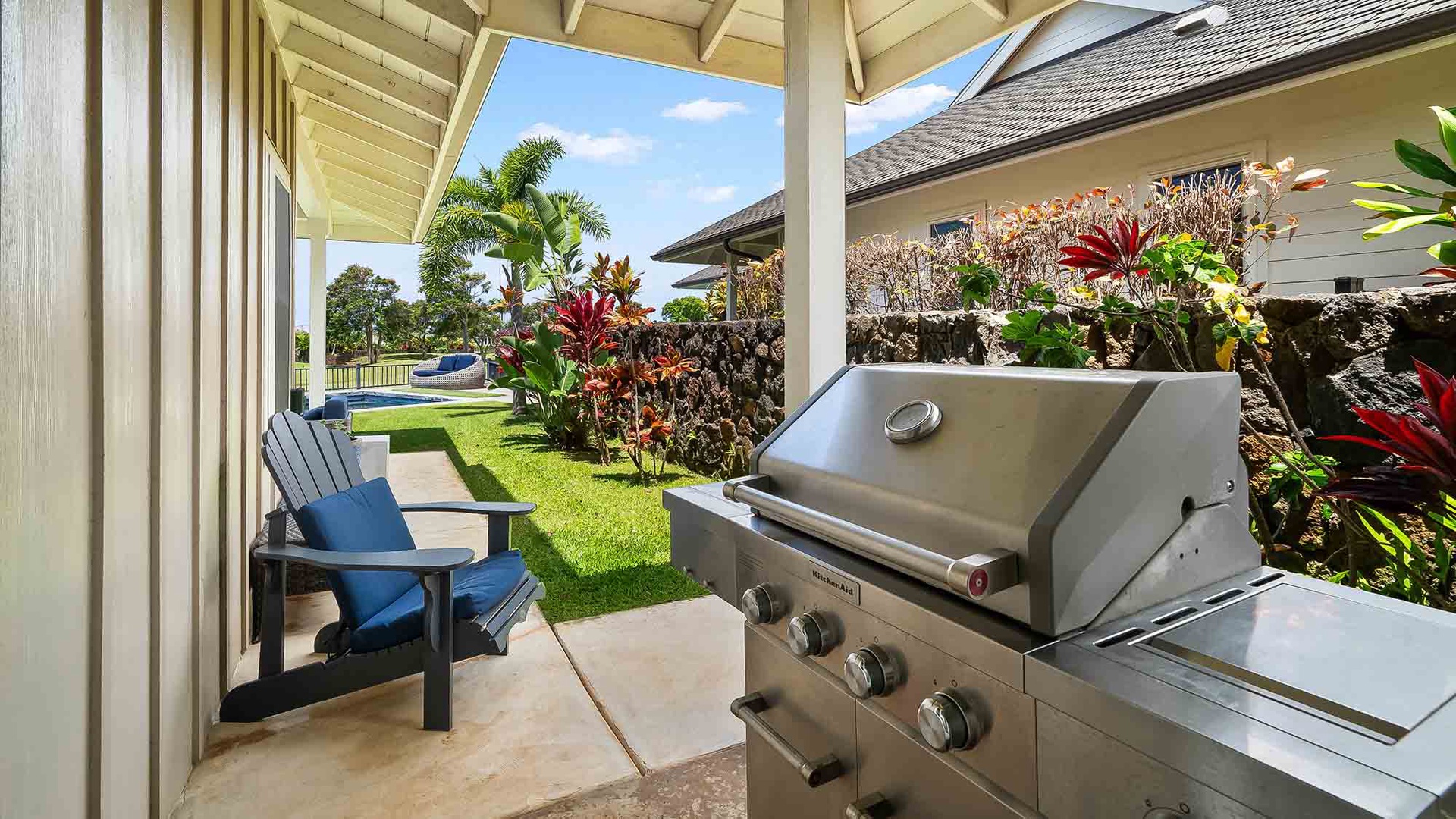 Your private lanai boasts a gleaming stainless-steel grill, perfect for grilling fresh local fish while surrounded by vibrant tropical plants. Unwind in the Adirondack chair and soak in the lush garden and distant views.