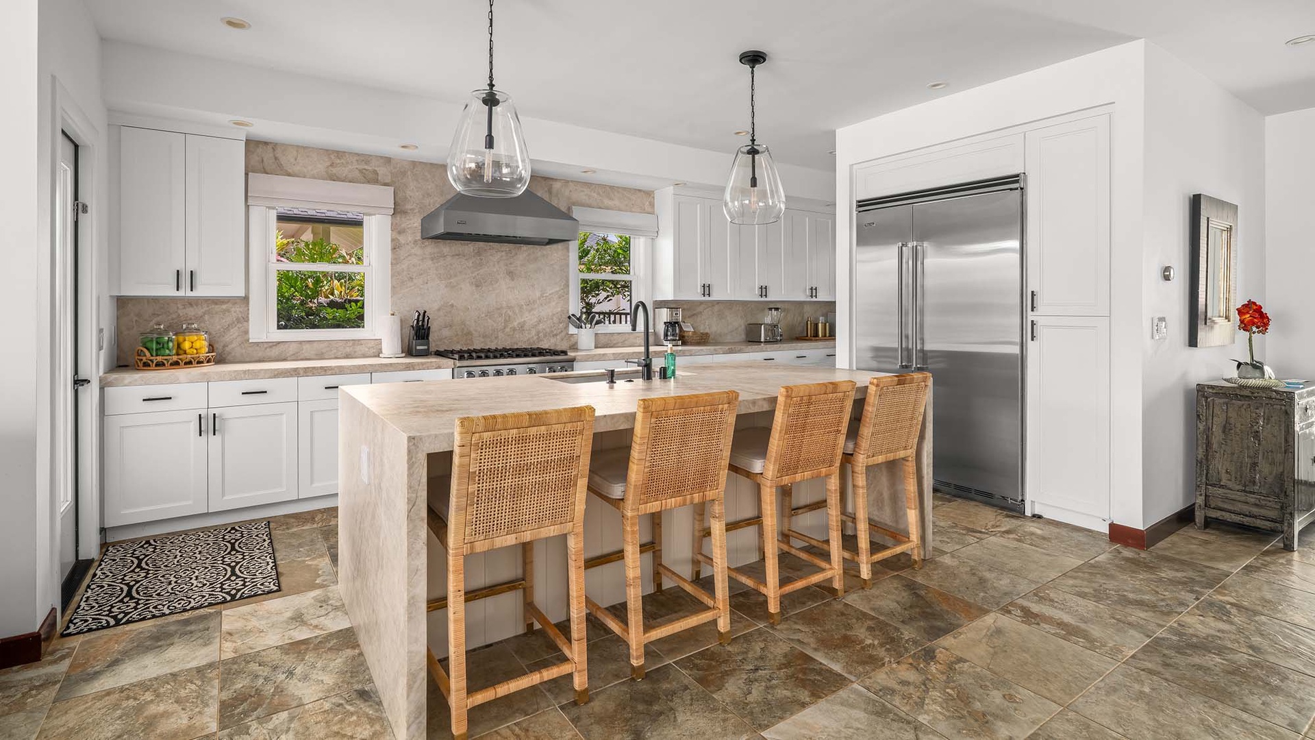 Picture yourself cooking in this spacious, sunlit kitchen with premium appliances, a generous island, and warm rattan seating—ready for your meals and gatherings.
