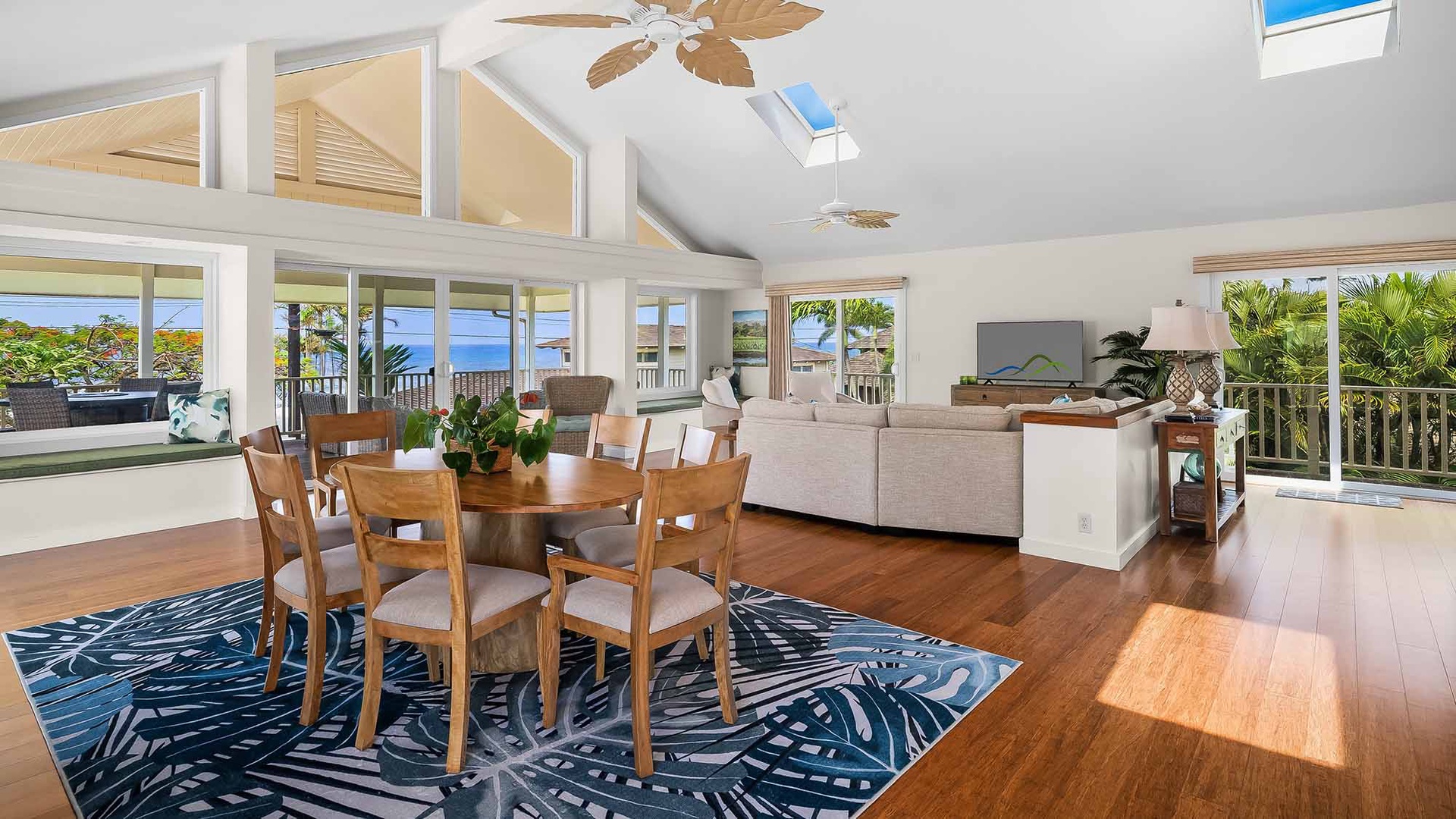 Relax in this bright open-concept living space where ocean views stretch across every window. Your dining table invites leisurely meals while tropical breezes flow through, and the cozy seating area beckons you to unwind in paradise.