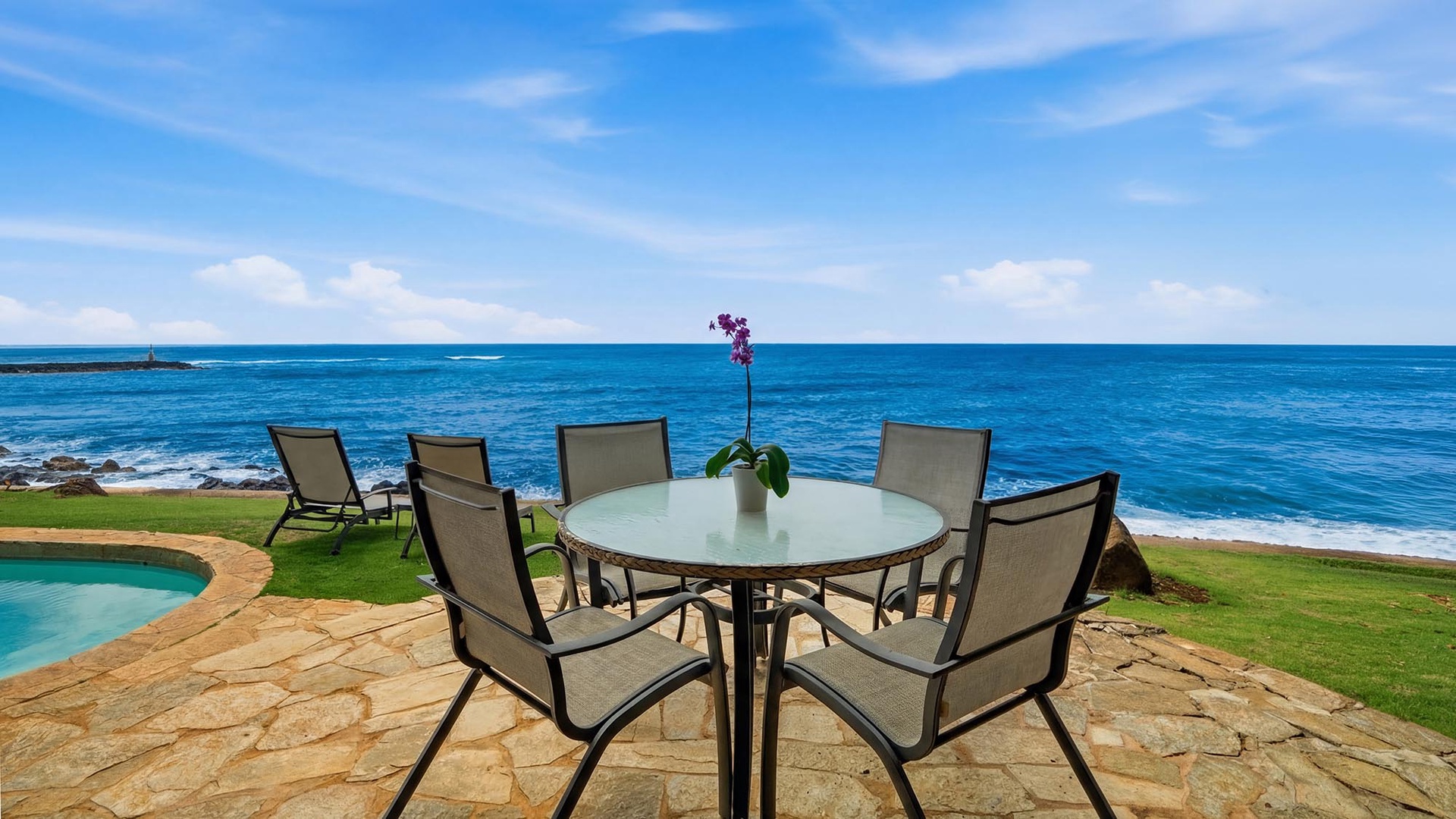 Your oceanfront dining table awaits with endless blue horizons and gentle waves as your backdrop.