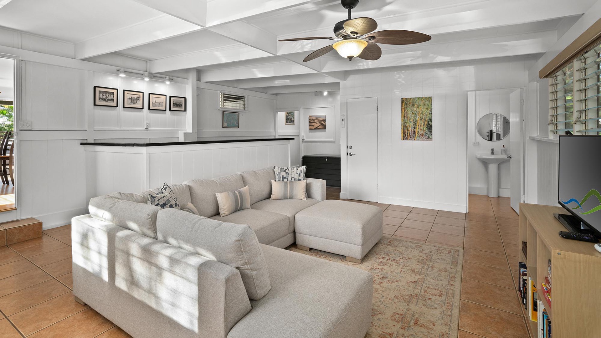 Relax in your spacious living room with plush sectional seating, exposed beams, and thoughtful artwork creating a perfect retreat.