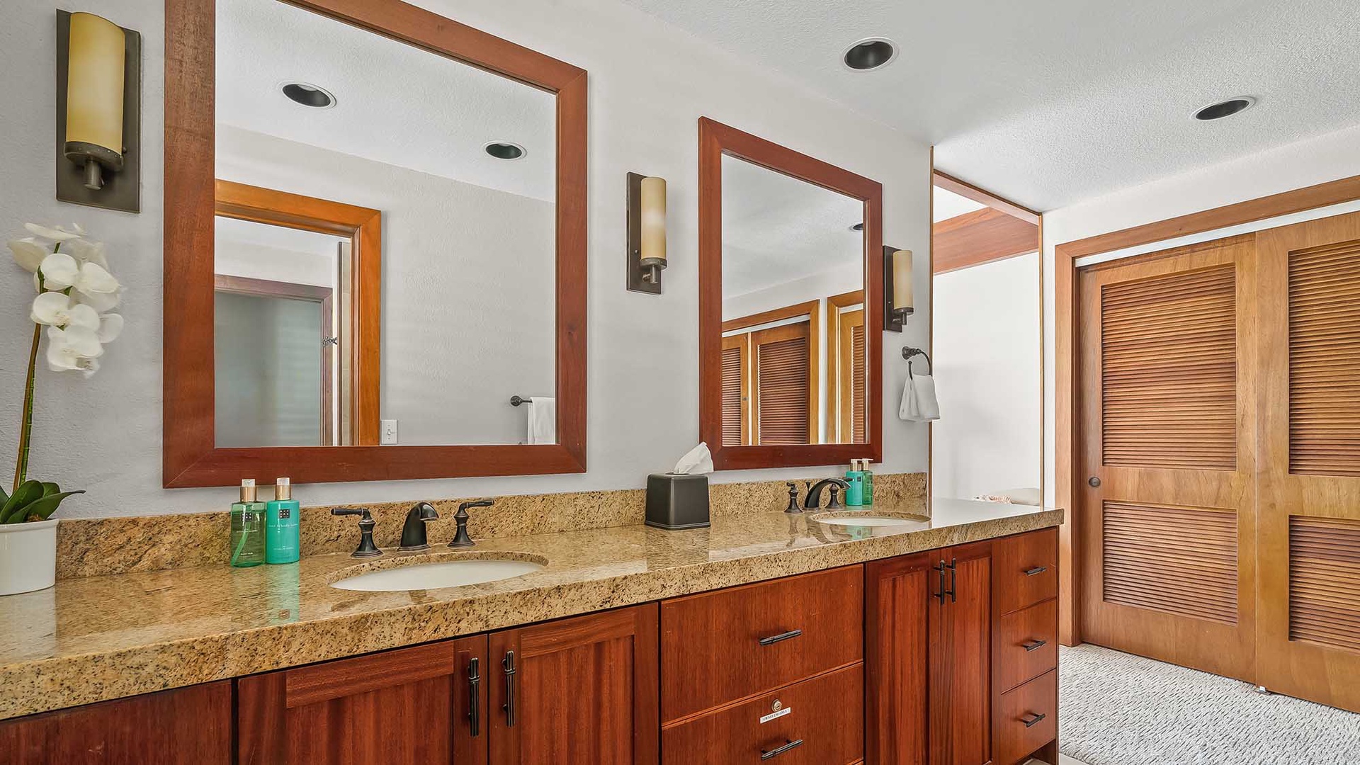 This bright bathroom offers double vanities with granite counters and elegant wood cabinetry, giving you plenty of space to prepare for your day in comfort.