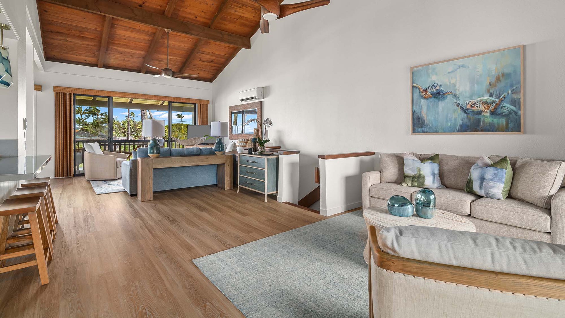 Unwind in your airy living space with vaulted wood ceilings, comfortable seating, and coastal touches that invite you to kick back and savor tropical breezes through wide balcony doors.