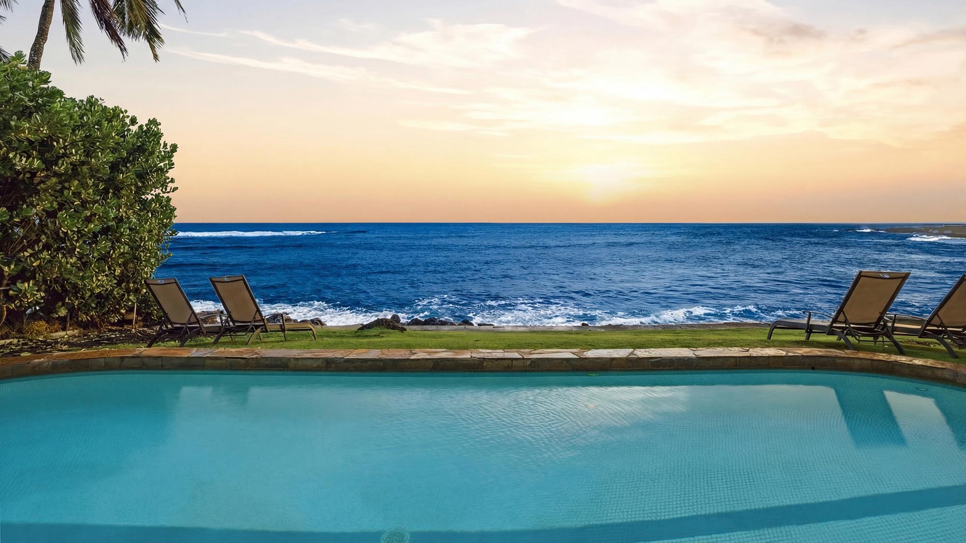 Infinity pool merges seamlessly with ocean horizon as sunset paints the sky in golden hues at this beachfront paradise.