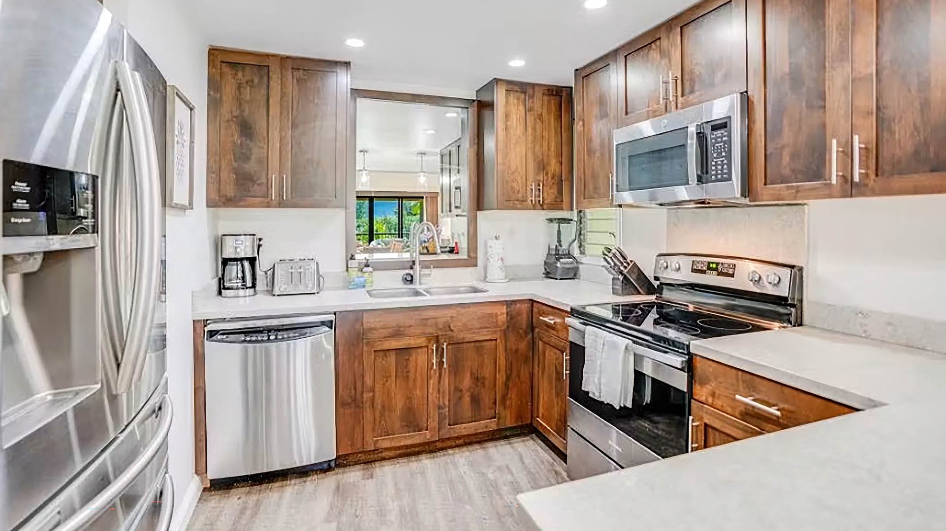 Your fully equipped kitchen features warm wood cabinetry, modern stainless steel appliances, and generous counter space—perfect for preparing everything from morning coffee to full family meals.
