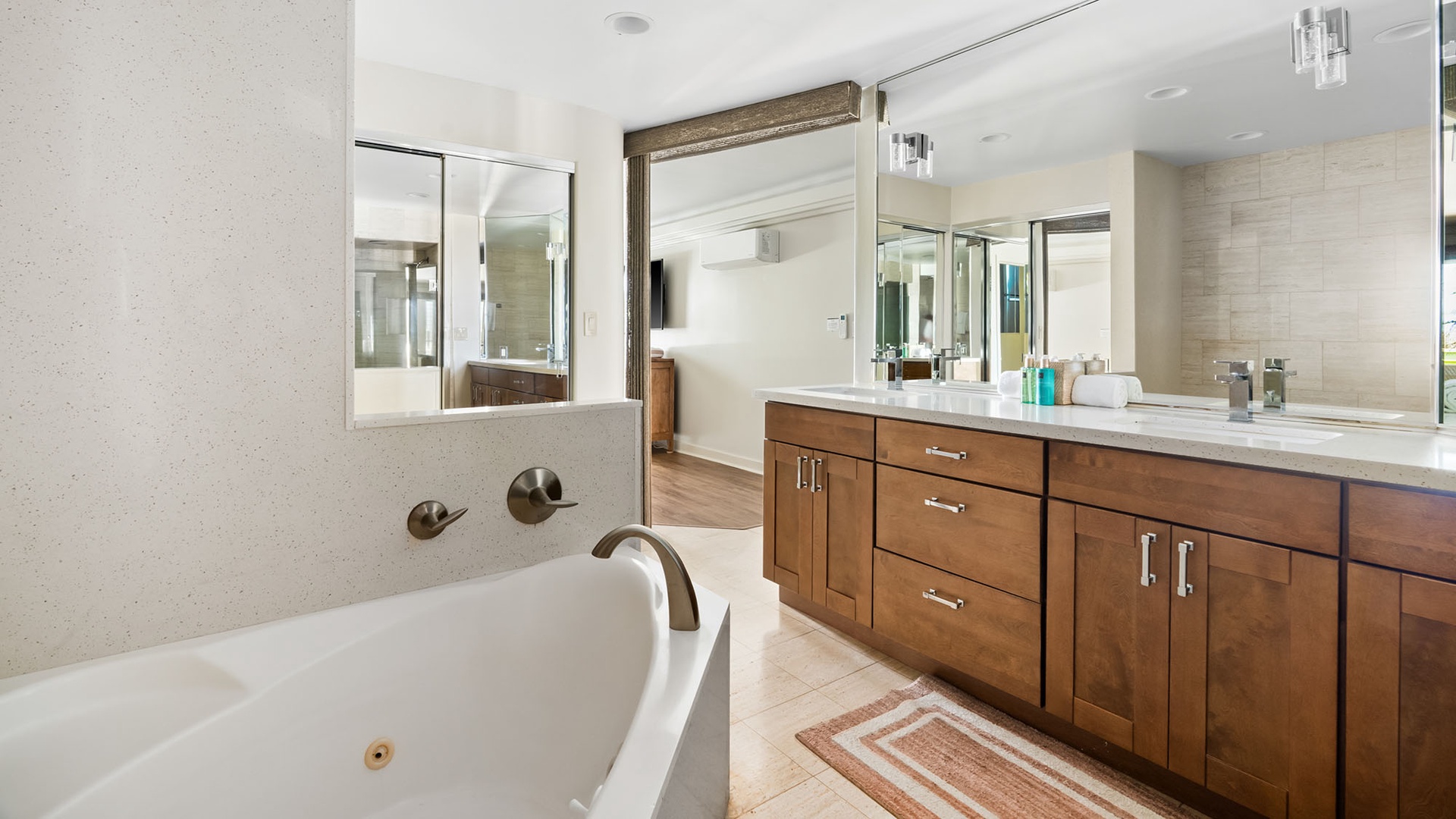 Unwind in your spacious bathroom featuring a luxurious soaking tub, elegant double vanity with ample storage, and sleek modern fixtures throughout.