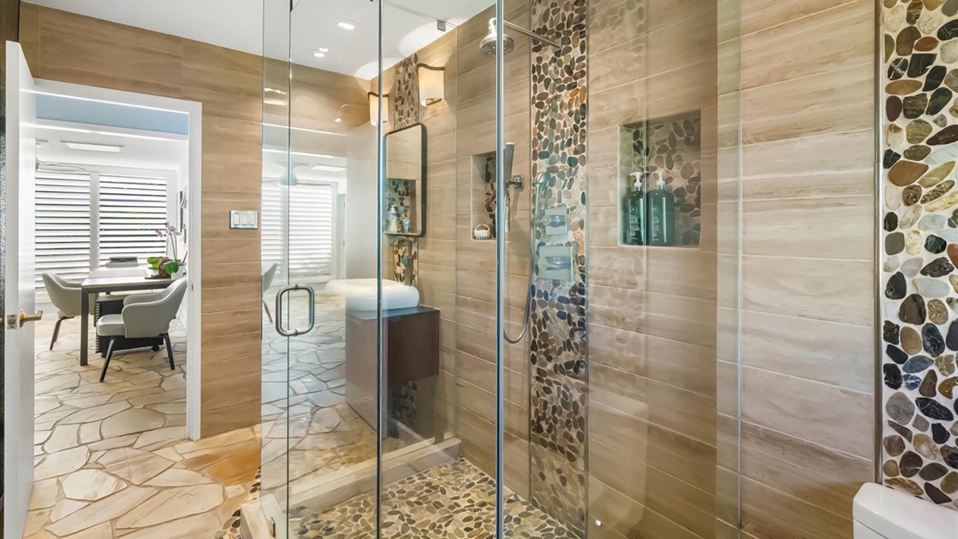 Step into your luxurious glass-enclosed shower featuring stunning stone tile work and spa-like natural accents that create the perfect retreat.