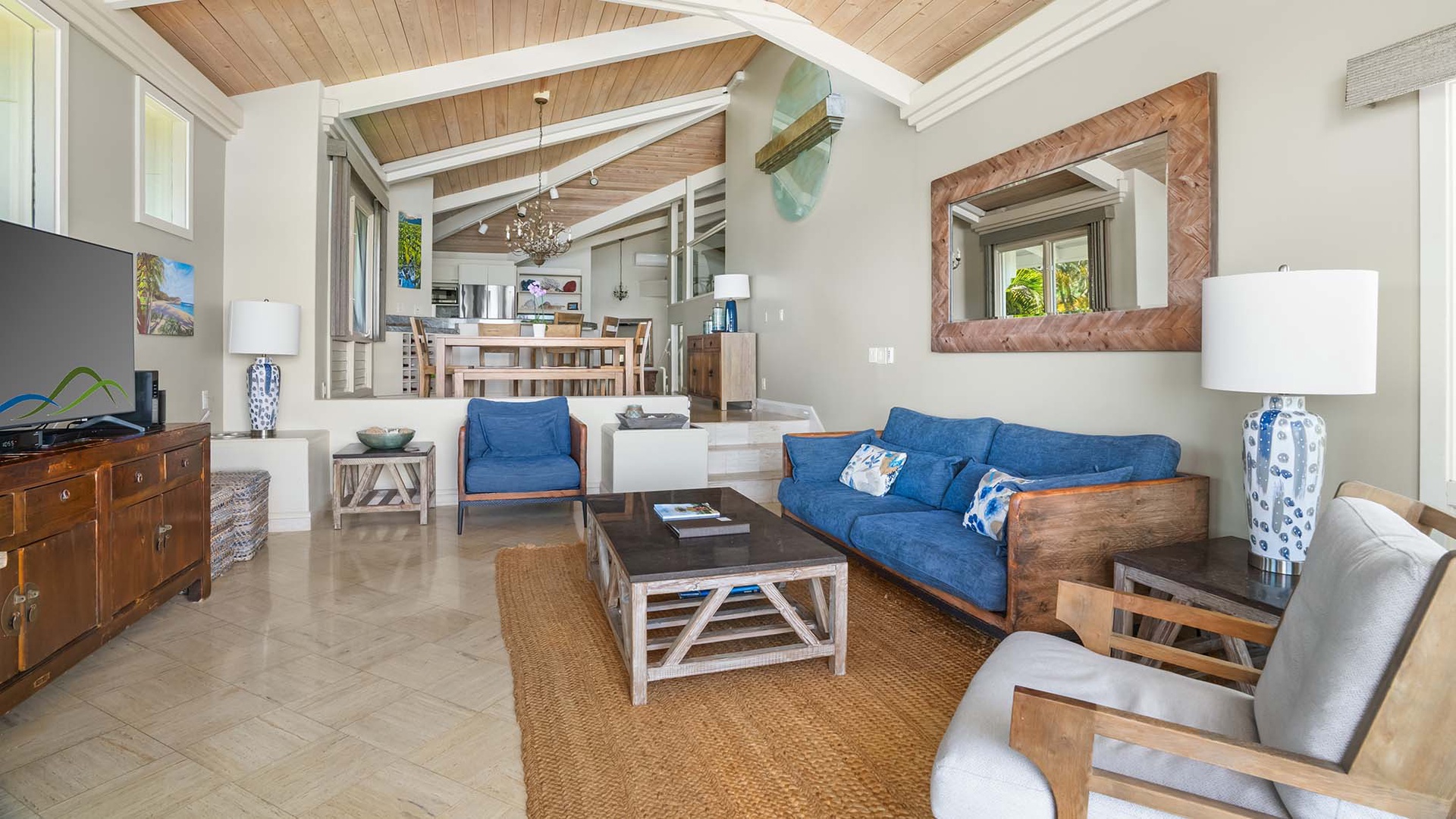 Relax in your spacious open-concept living area with vaulted wood ceilings, coastal-inspired décor, and comfortable seating flowing seamlessly into the fully equipped kitchen—perfect for unwinding after your island adventures.