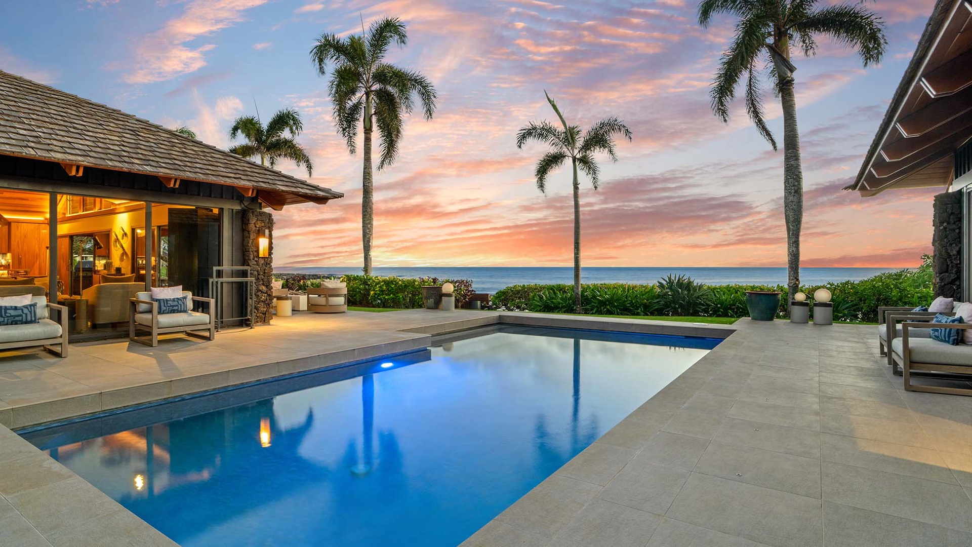 Stunning beachfront villa with private pool and tropical palms at sunset, creating the perfect paradise retreat setting.
