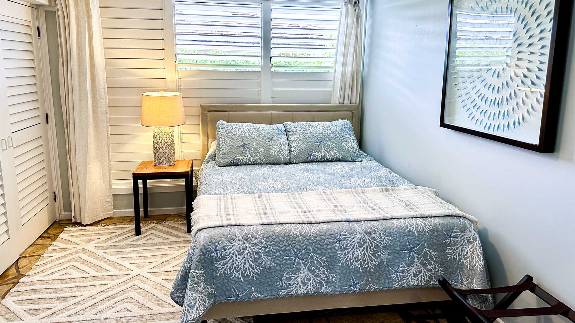 Sink into this cozy bedroom where soft blue linens and warm lighting create your perfect retreat after island adventures.