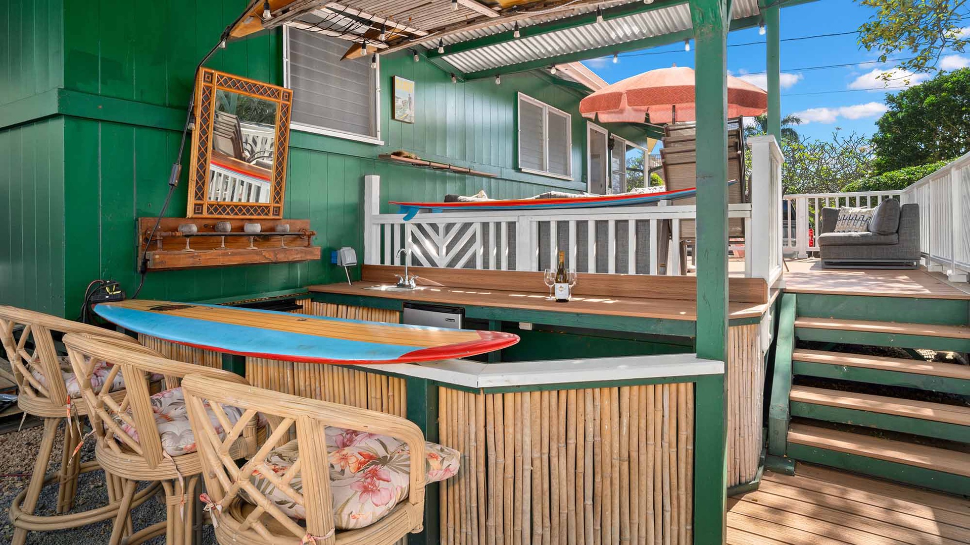 Your private tiki bar awaits with tropical seating and surfboard details, perfect for evening cocktails under string lights.