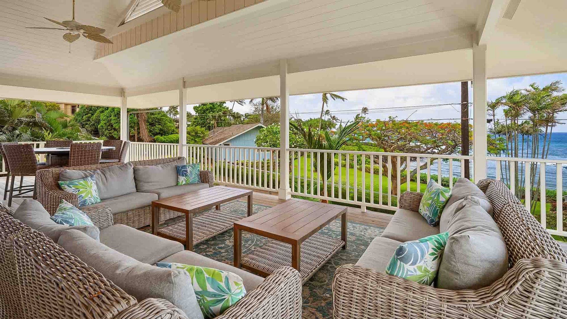 Relax in your private covered lanai with plush seating, tropical breezes, and stunning ocean views framed by swaying palms and lush gardens.