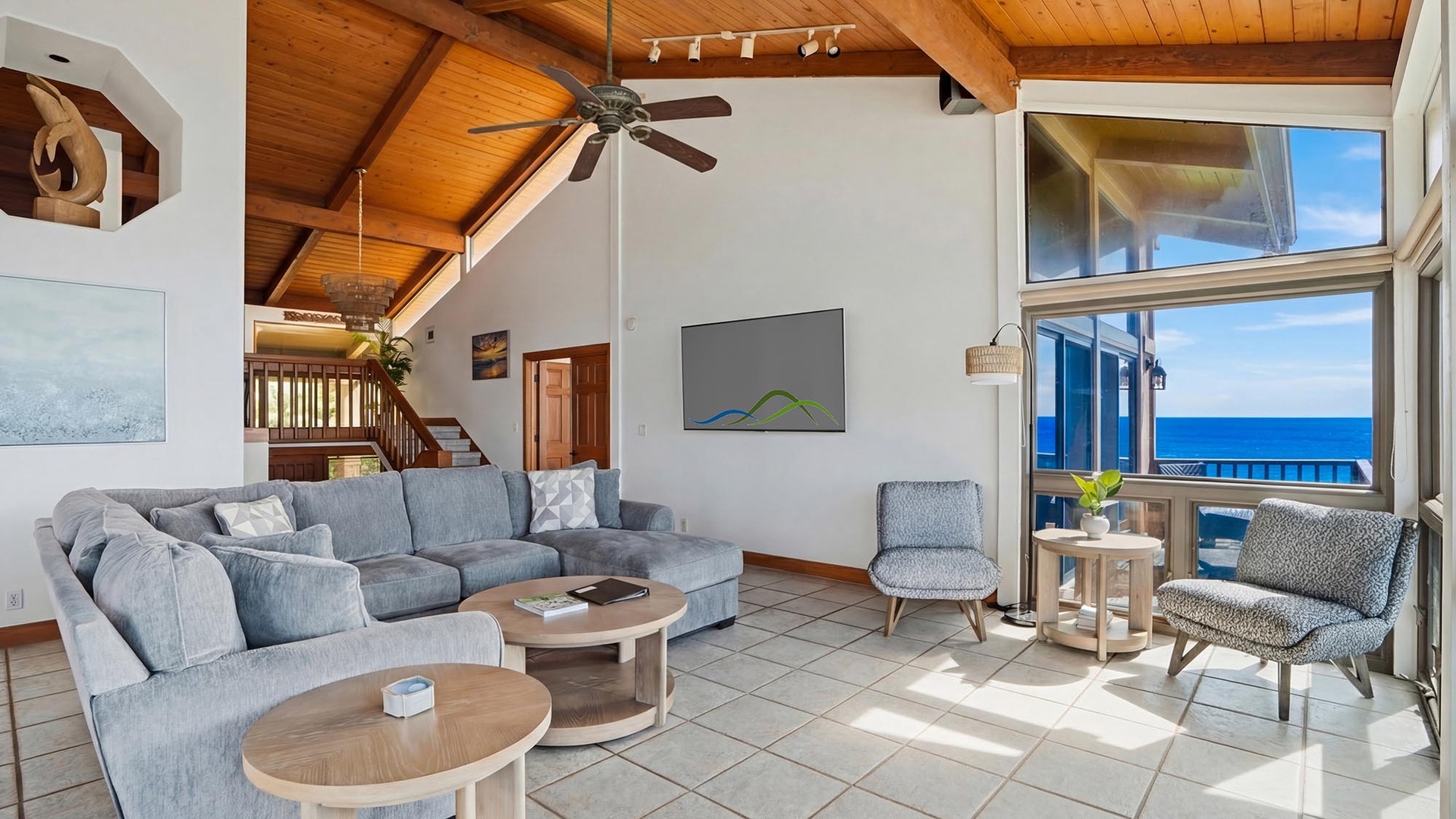 Relax in your open-concept living room with soaring wood ceilings, where ocean breezes flow through while you enjoy stunning sea views.