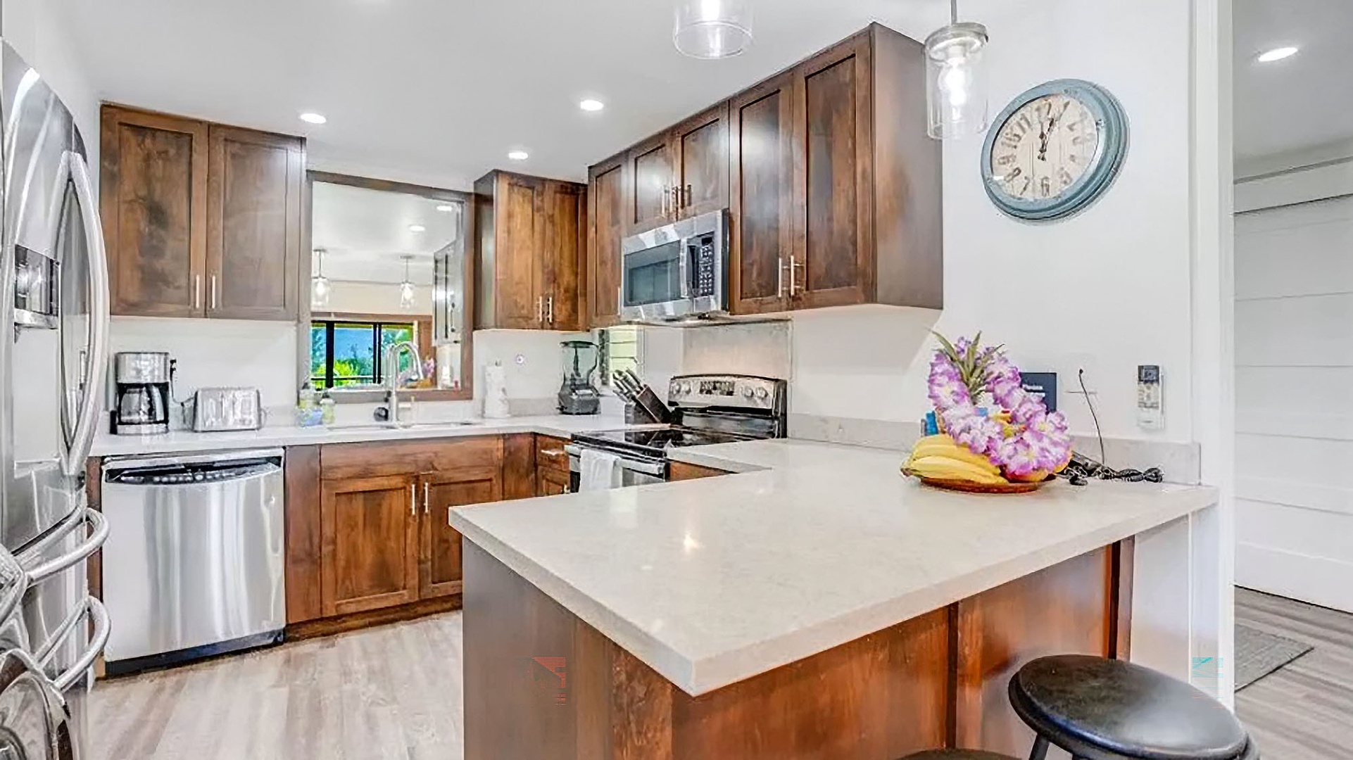 Your fully-equipped island kitchen features warm wood cabinetry, stainless appliances, and bright countertops—perfect for whipping up holiday feasts or quick island-style breakfasts together.