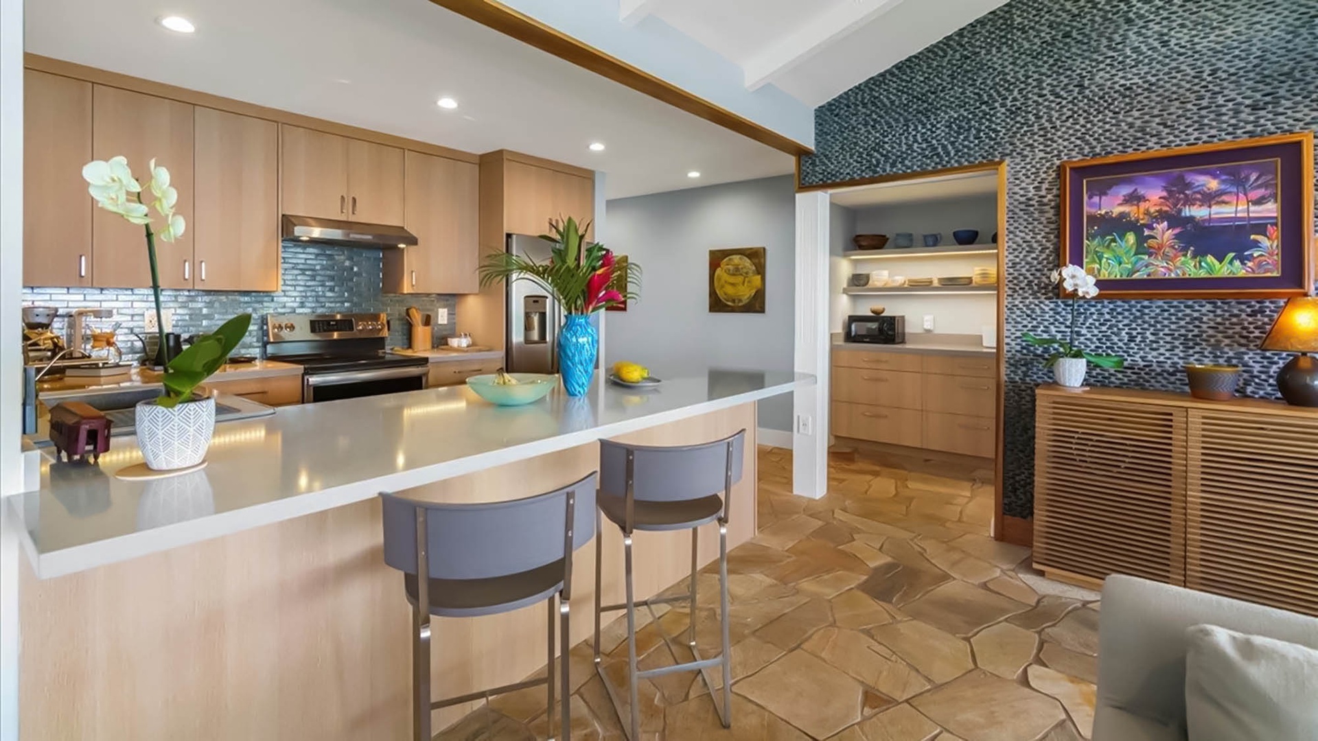 Your modern kitchen features sleek countertops, tropical flowers, and warm wood accents creating the perfect space for preparing island-inspired meals.