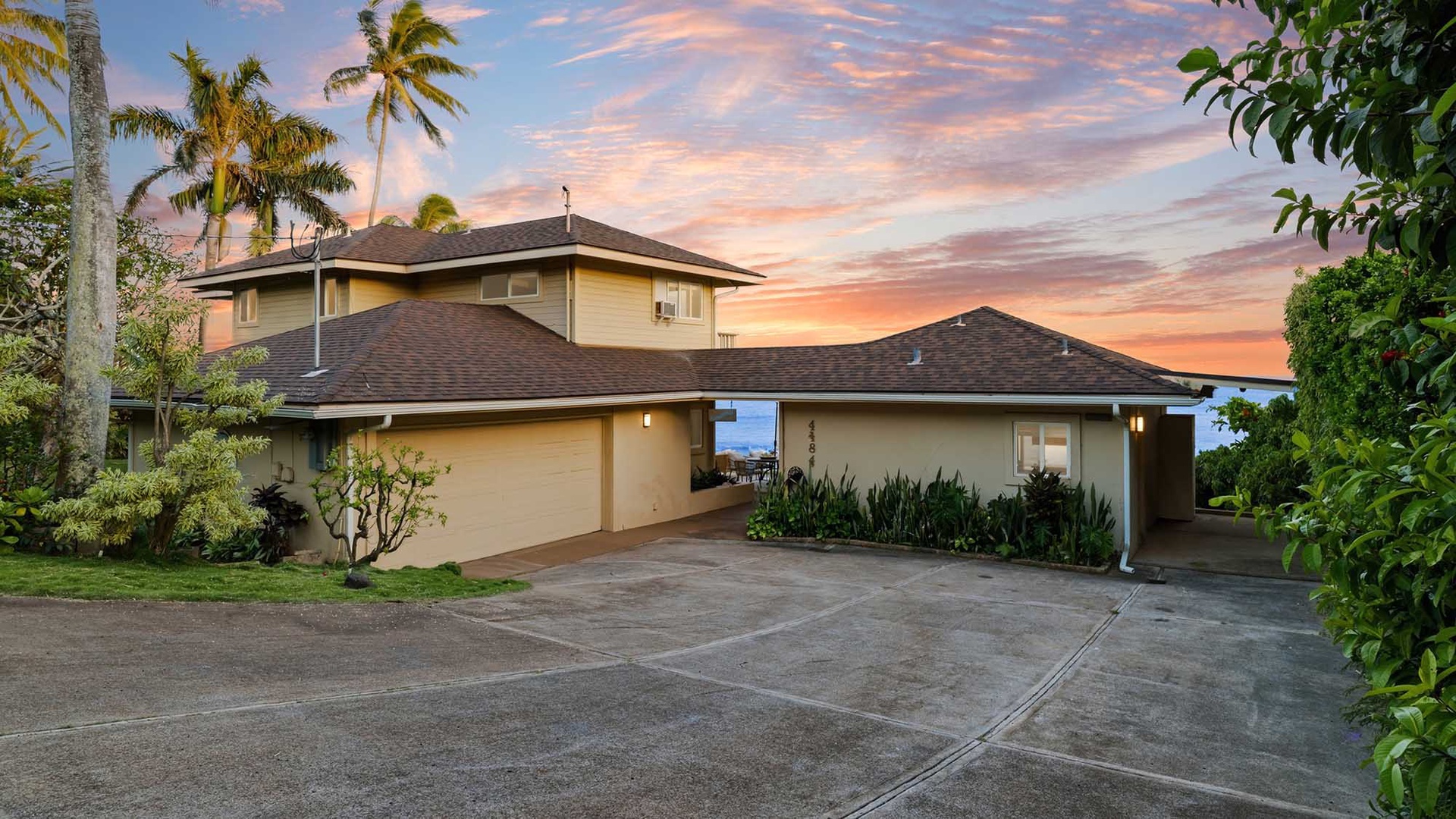 Beneath swaying palm trees and a pastel sunset sky, this welcoming tropical home offers the perfect setting for a relaxing Hawaiian escape.