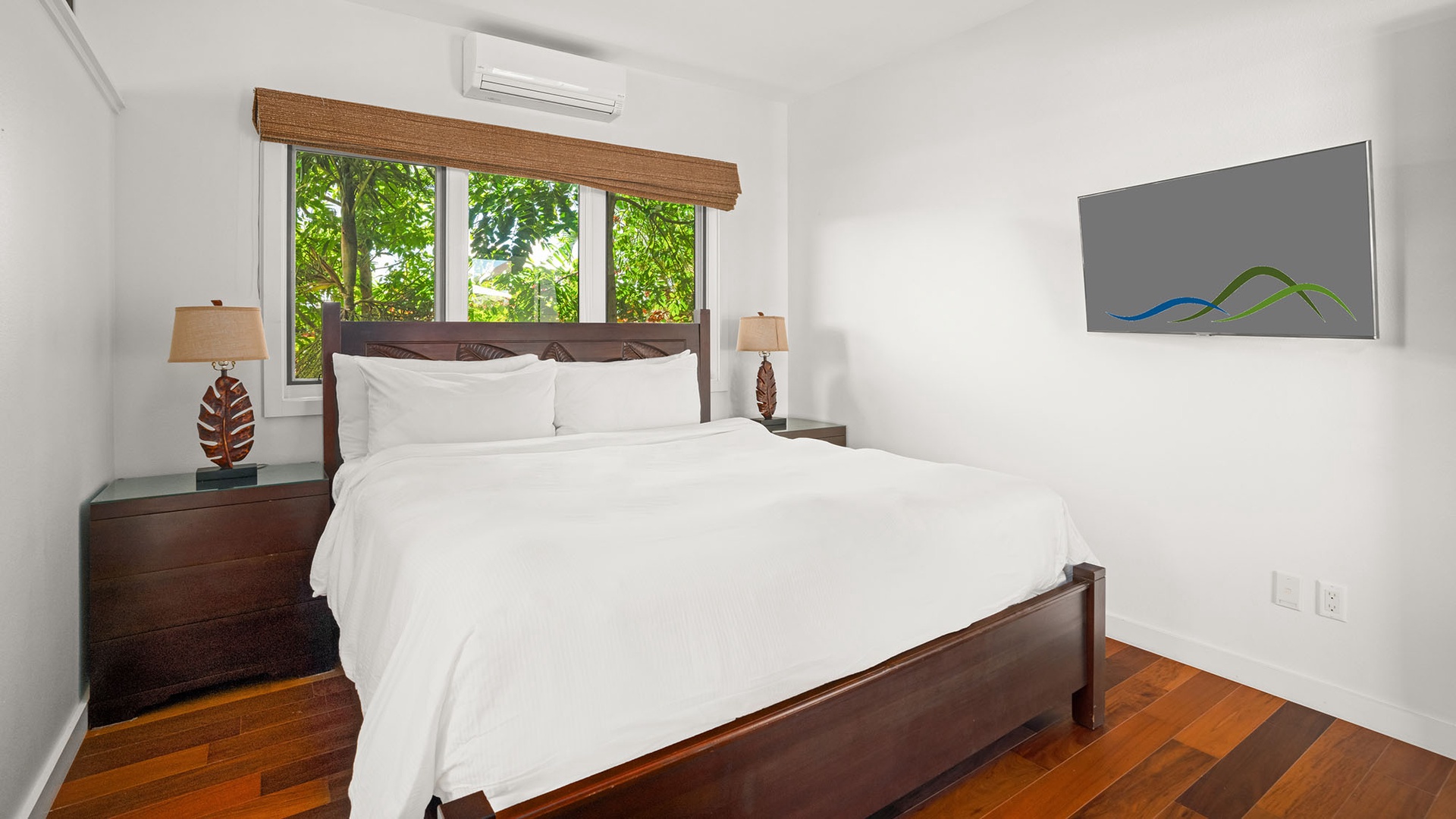 Wake up to lush tropical greenery framed by your window, where crisp white linens and warm wood tones create your serene retreat.