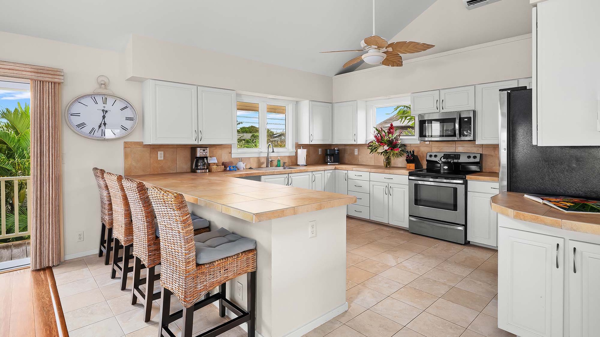 Gather around the sunlit island in your spacious kitchen, where tropical breezes flow through open windows and wood countertops invite meal prep. Sleek appliances and coastal style make your stay effortlessly comfortable and bright.
