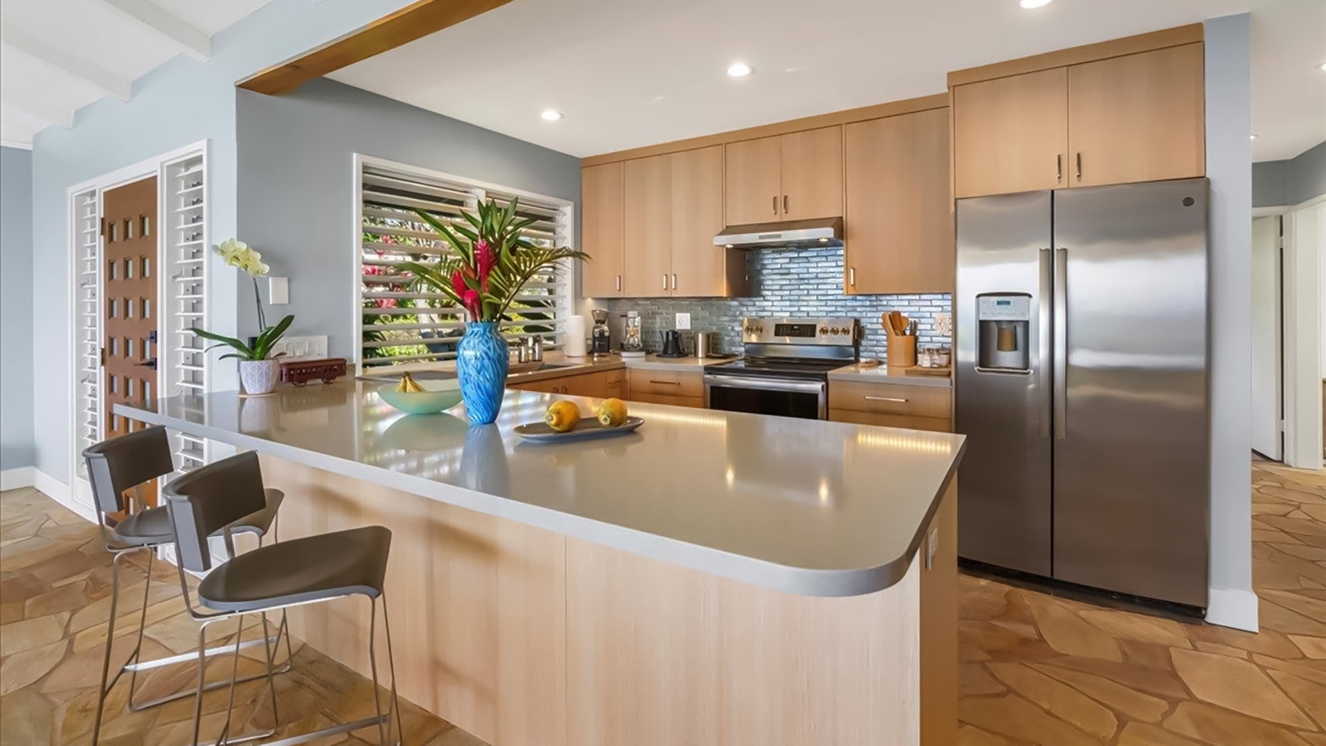 Cook memorable meals in your modern kitchen with sleek appliances, spacious island, and tropical touches that make you feel at home.