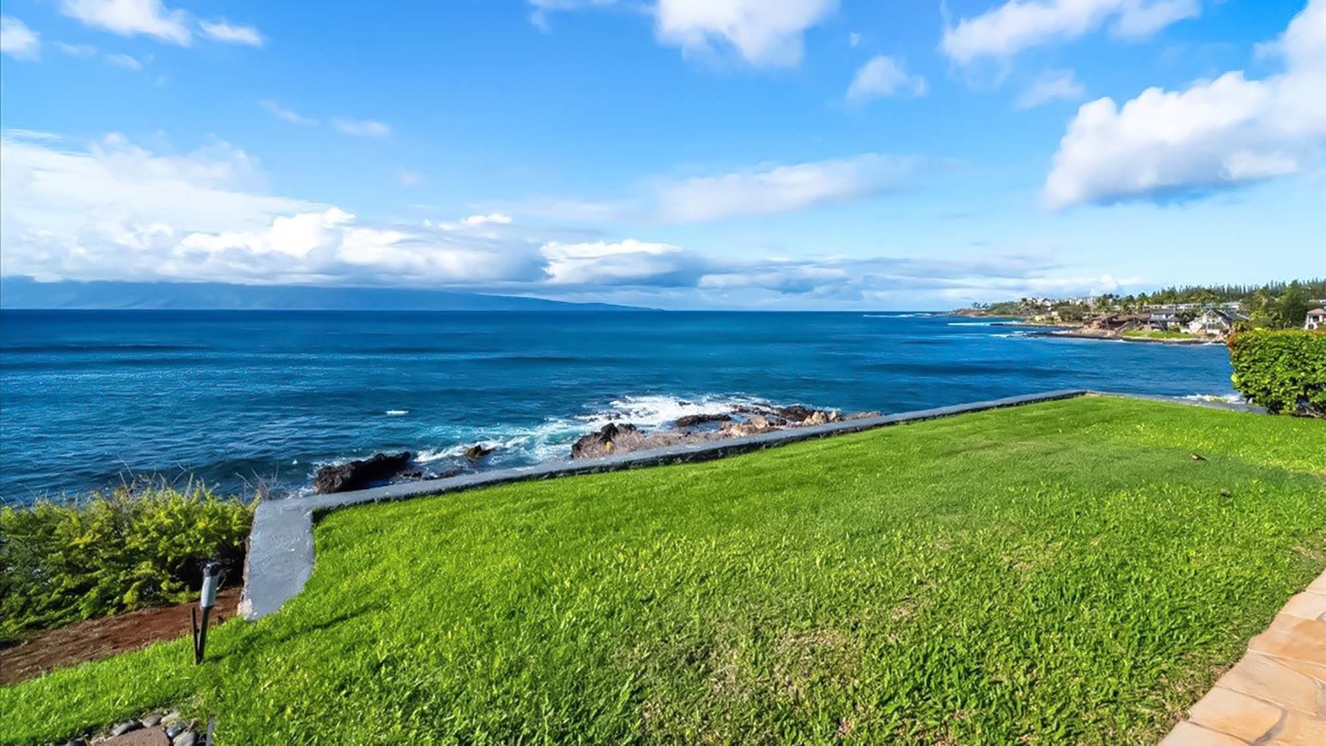 Stunning oceanfront grounds showcase pristine blue waters and dramatic coastline views stretching to the horizon.