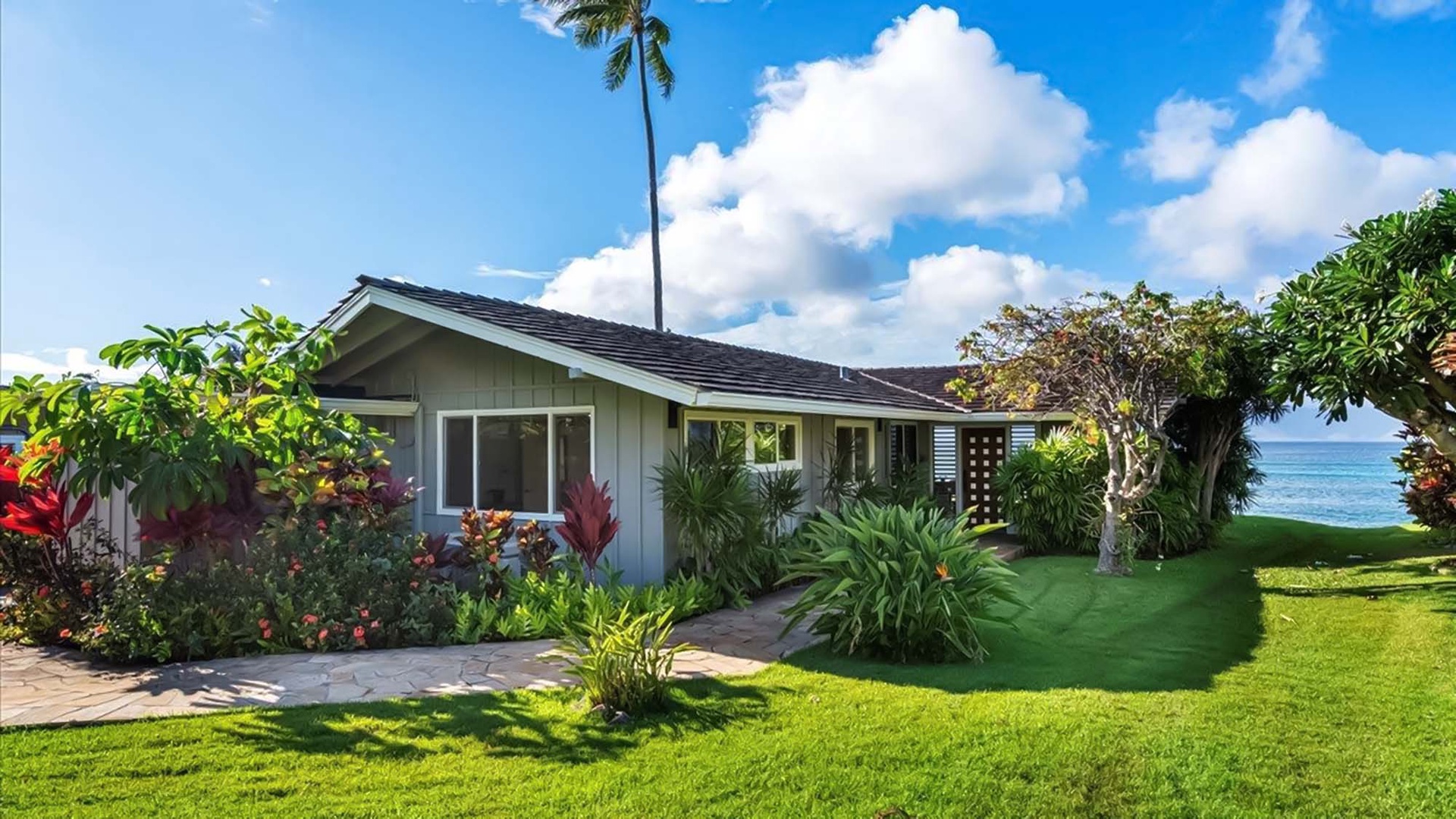 Charming beachfront property nestled among tropical gardens with direct ocean access and panoramic sea views.