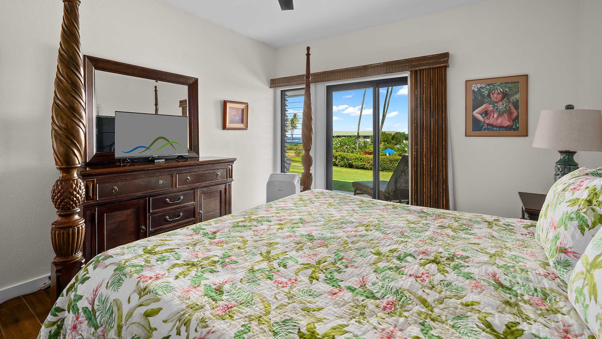 Drift off in a spacious bedroom with tropical bedding, a four-poster bed, and garden views visible through sliding glass doors—your peaceful island retreat awaits.