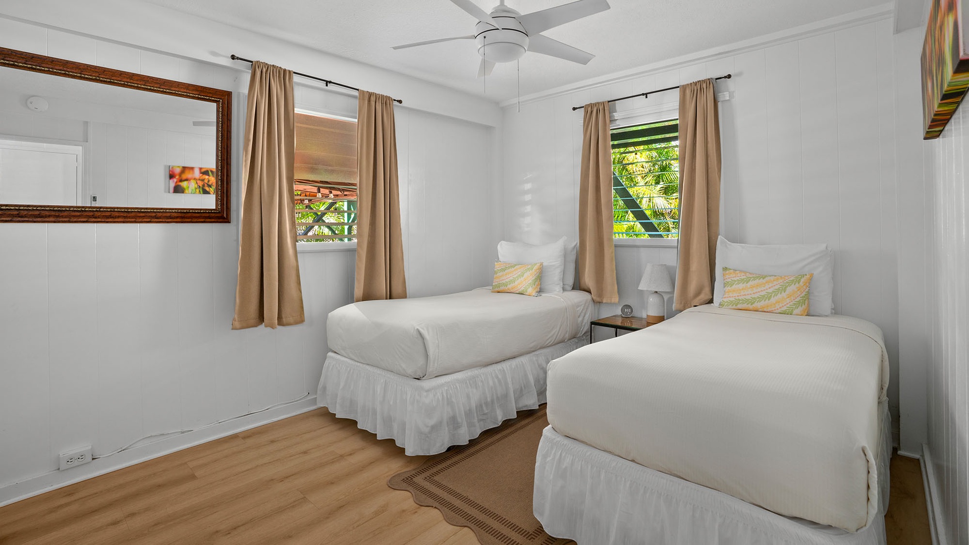 Drift off beneath the gentle breeze of your ceiling fan in this peaceful bedroom with two cozy twin beds and soft natural light streaming through the windows.