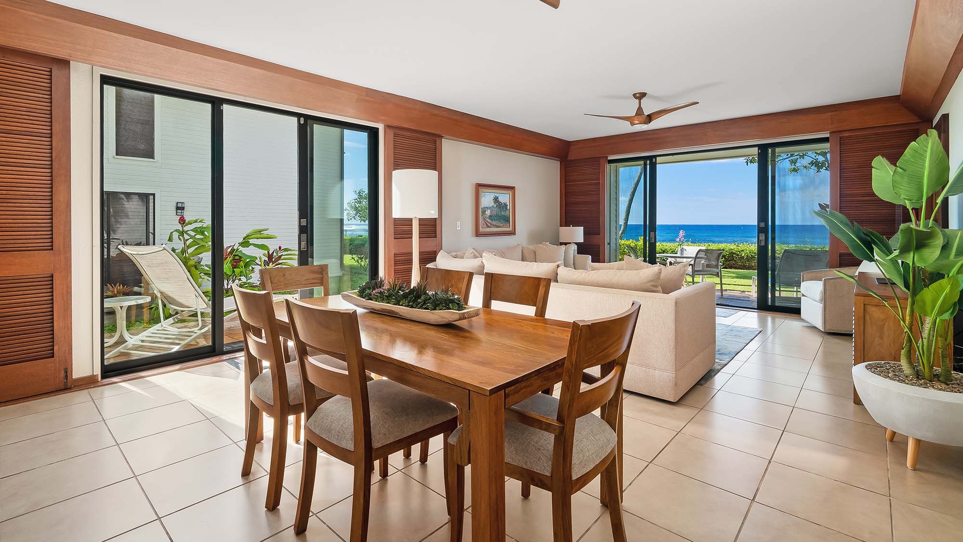 Picture yourself gathered around this beautiful wooden dining table, with sparkling ocean views just beyond your living space and warm tropical breezes flowing through open glass doors.