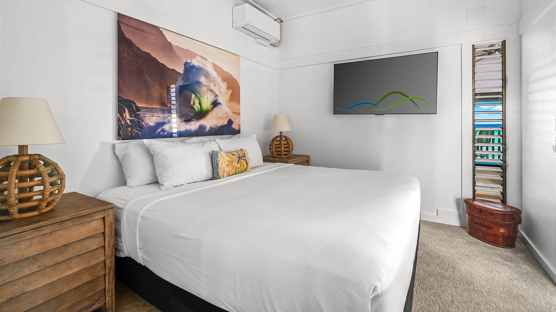 Sink into crisp white linens and let vibrant artwork inspire your dreams. This cozy bedroom blends coastal charm with modern comfort for your perfect escape.