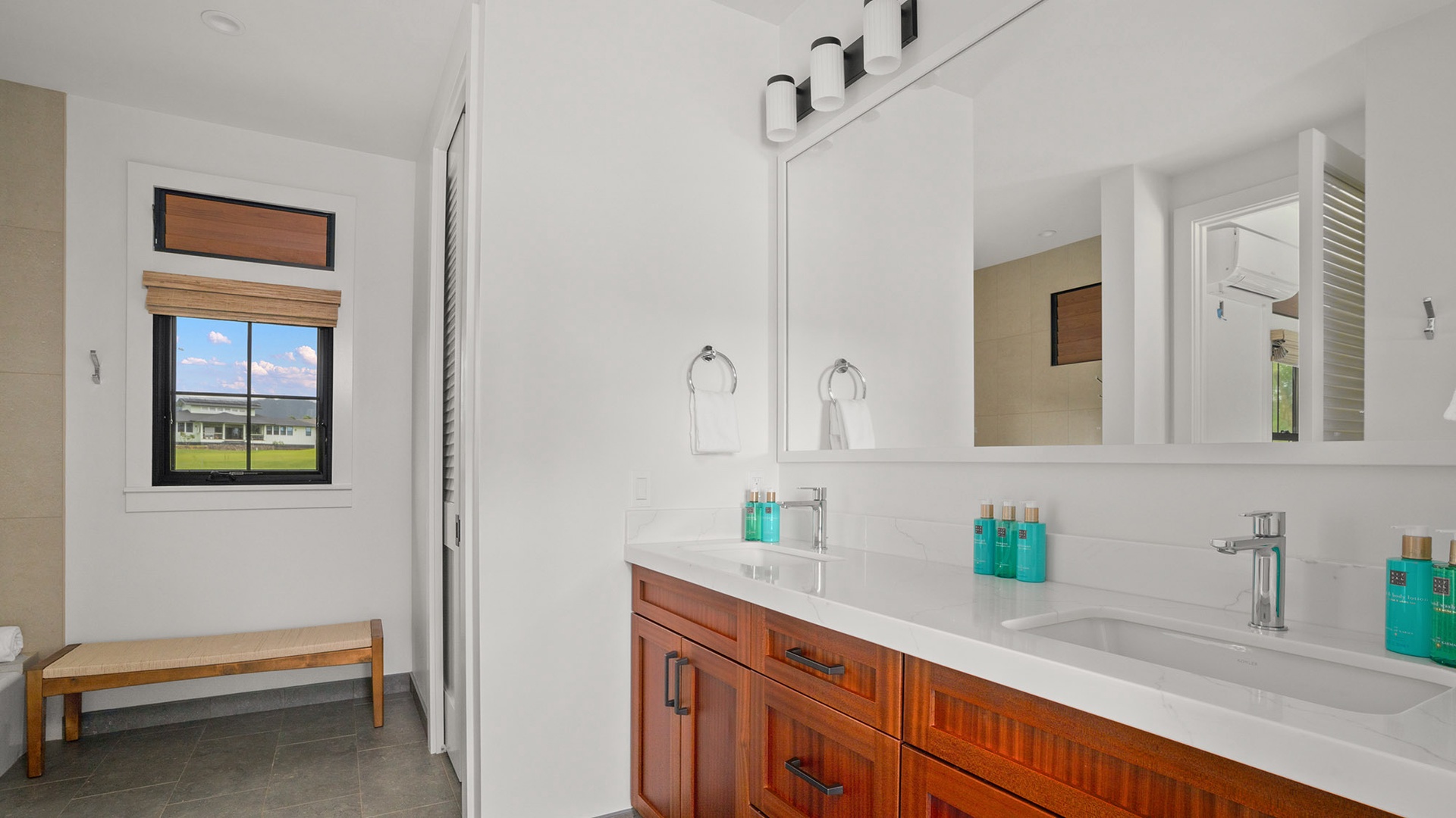Your spacious dual-sink bathroom features warm wood vanity and premium amenities, perfect for morning routines.