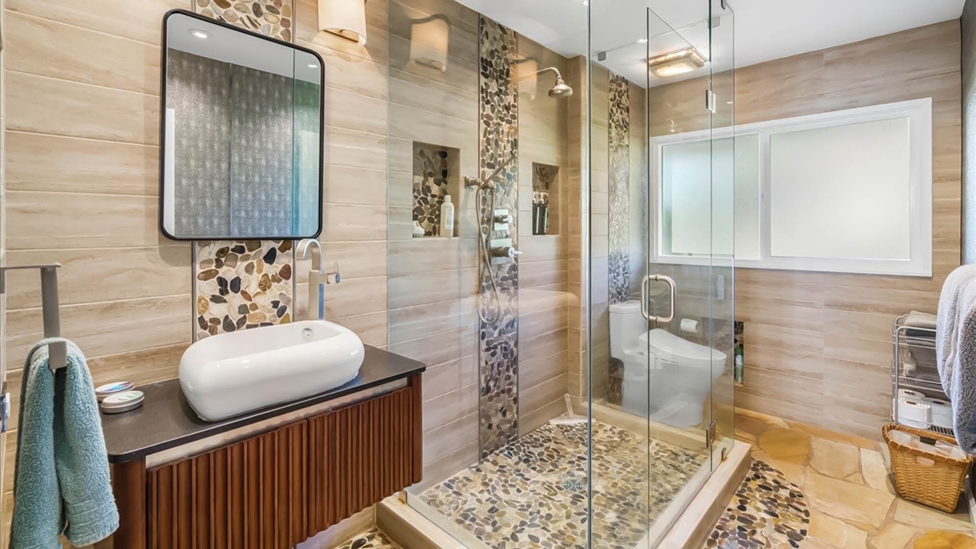 Your private spa-like bathroom features stunning stone mosaics and a luxurious glass shower that transforms daily routines into indulgent escapes.