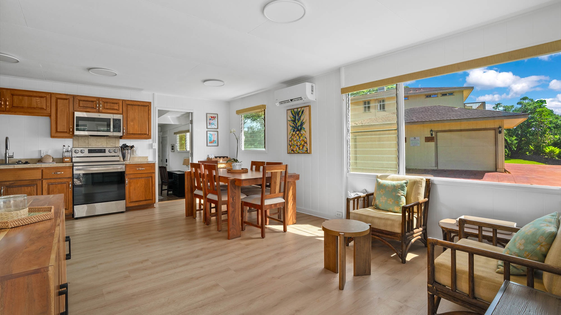 Sunlight pours through open windows into your cheerful open-plan space, where the kitchen flows effortlessly into the dining and living areas—perfect for gathering around a home-cooked meal or unwinding with tropical breezes drifting through.