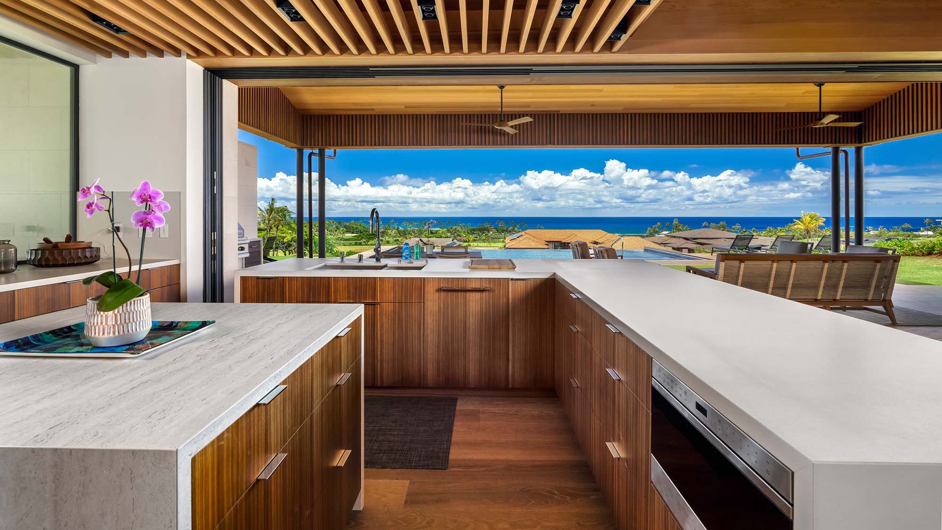 Gather around this stunning kitchen island with endless ocean views framing your cooking space. The open design invites you to prepare meals while soaking in the tropical breeze and blue horizon.