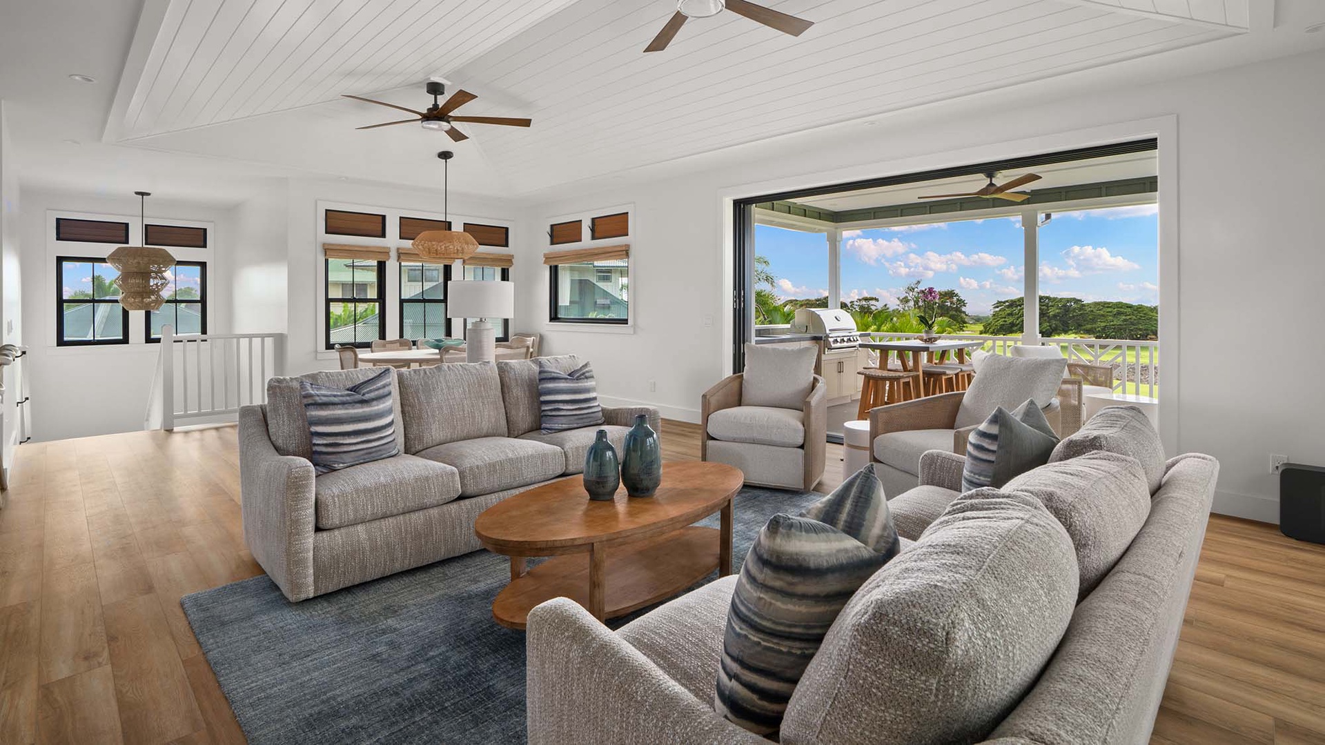 Relax in your spacious living room with plush seating and stunning views through expansive glass doors to the outdoor terrace.