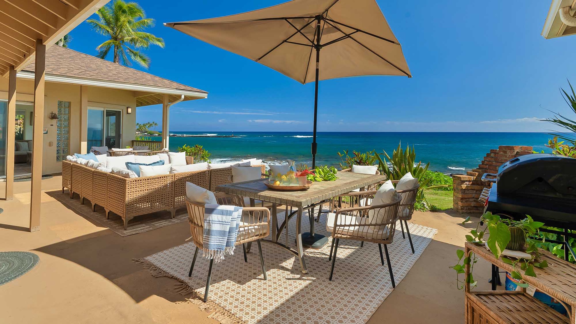 This oceanfront patio invites you to dine al fresco under swaying palms, with plush seating and unobstructed turquoise waves just steps from your door.