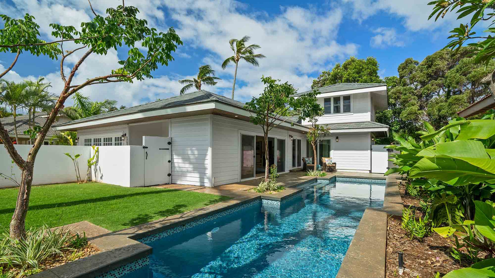 Modern tropical retreat featuring a private pool framed by lush landscaping and swaying palms.