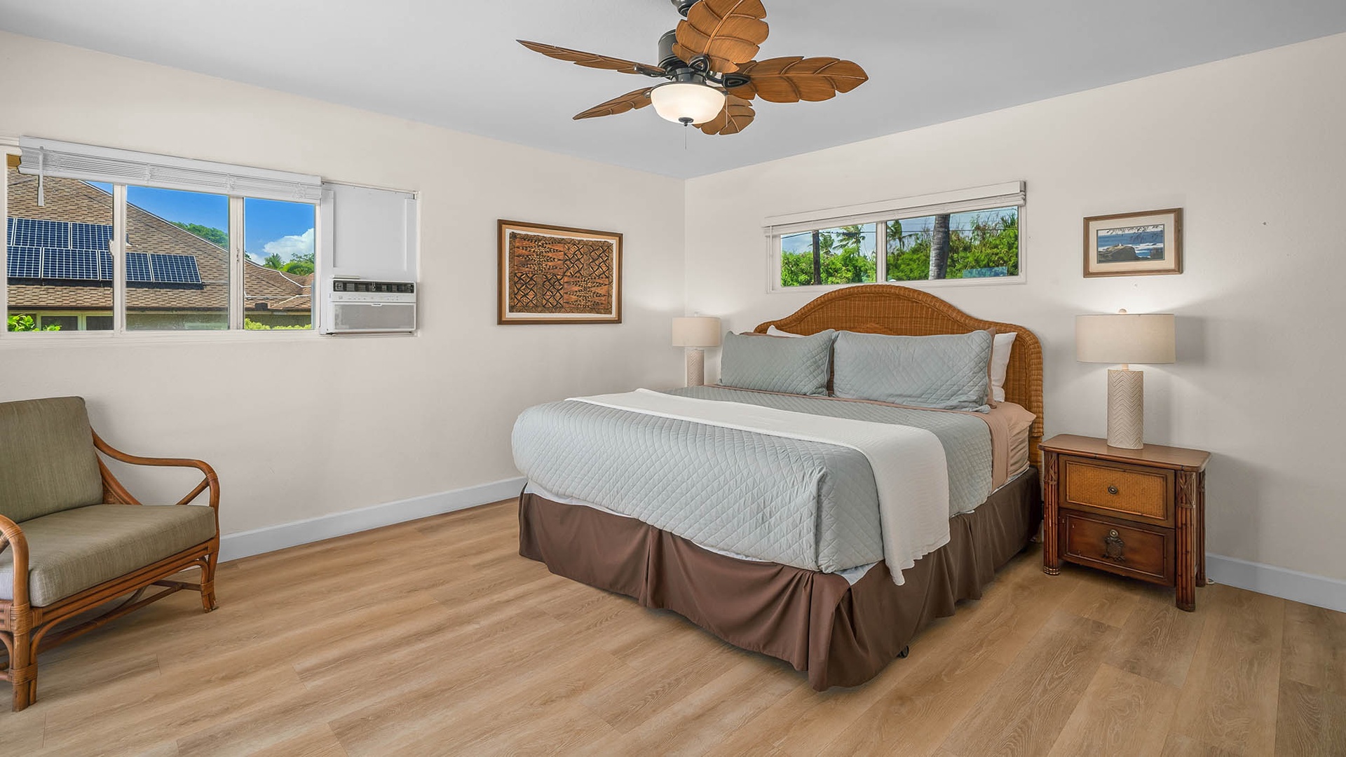 Slip into your peaceful retreat with a plush bed dressed in soft linens and a tropical ceiling fan overhead. Natural light pours in through multiple windows, while rattan touches and warm wood tones wrap you in island-inspired comfort.